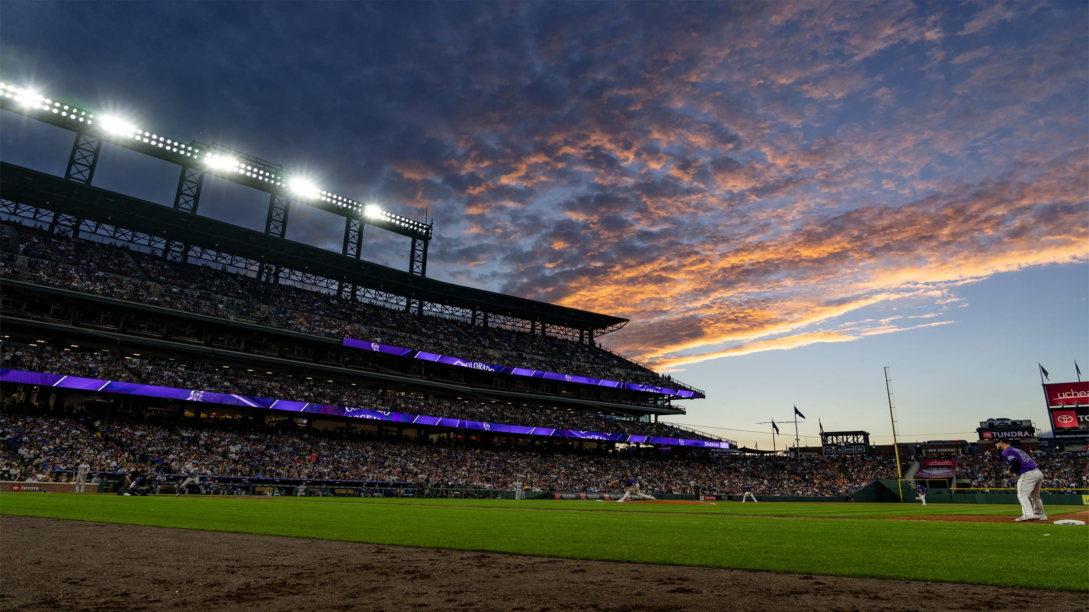 Field Level view at the ribbon boards and live action of the players with a sunset