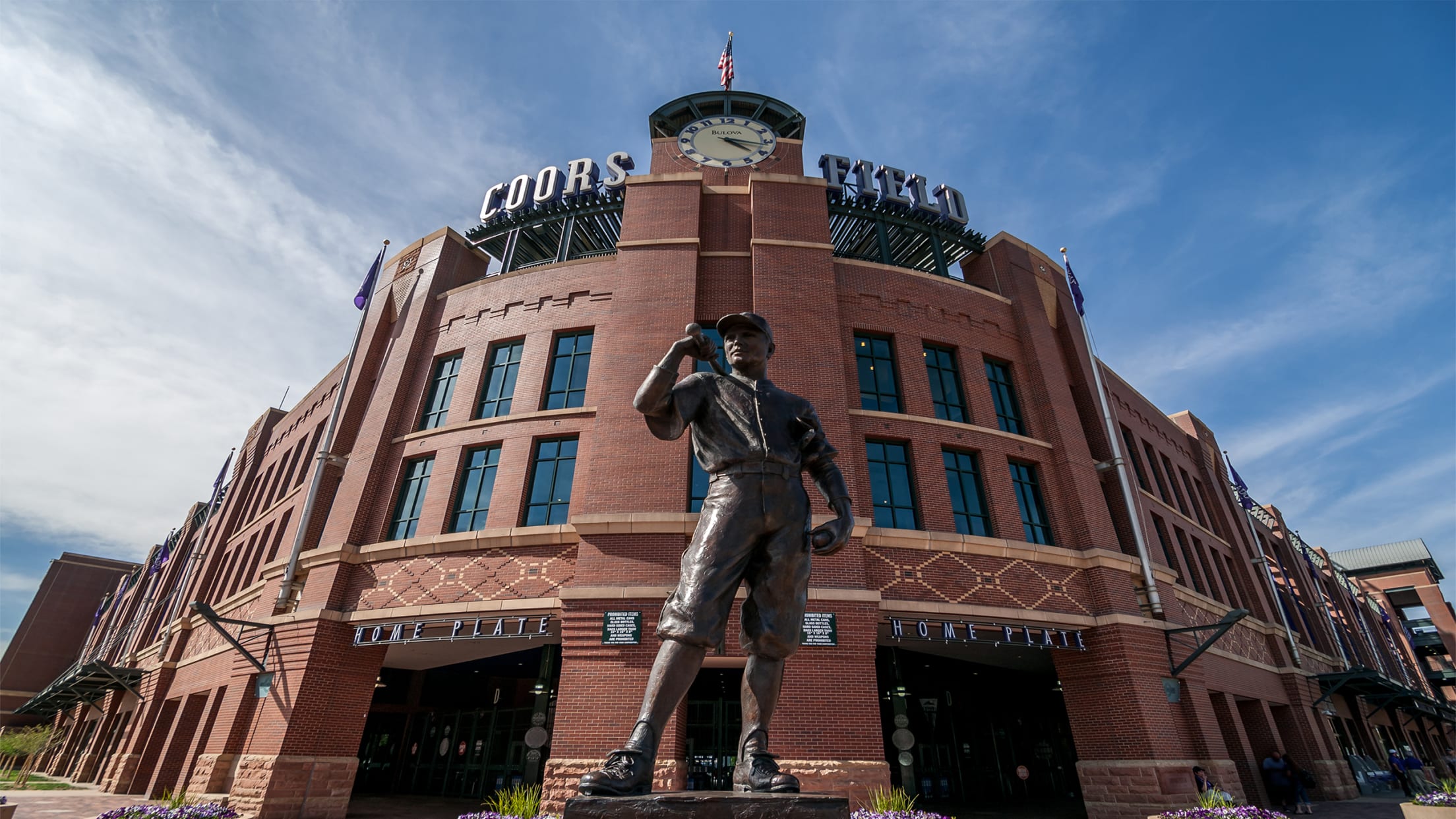 Coors Field home plate entrance with iconic statue and blue sky