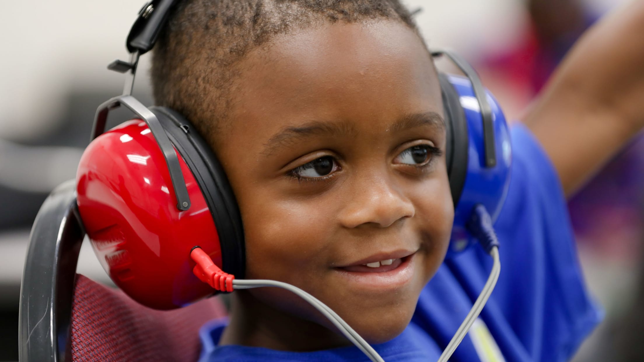 A young boy wearing head phones participates in a hearing test