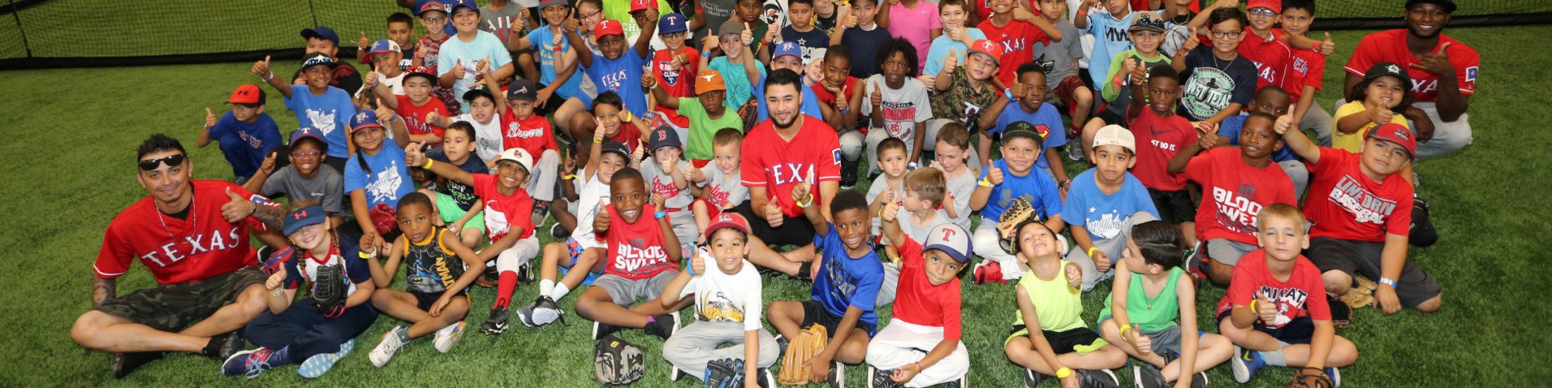 Young softball and baseball players pose for a big group shot alongside MLB players.