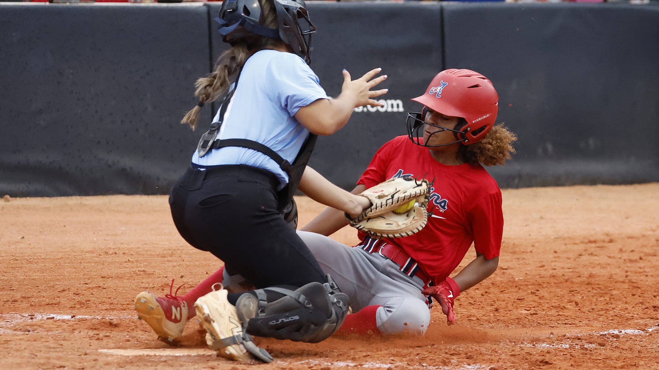 The catcher tags the runner sliding into home plate.
