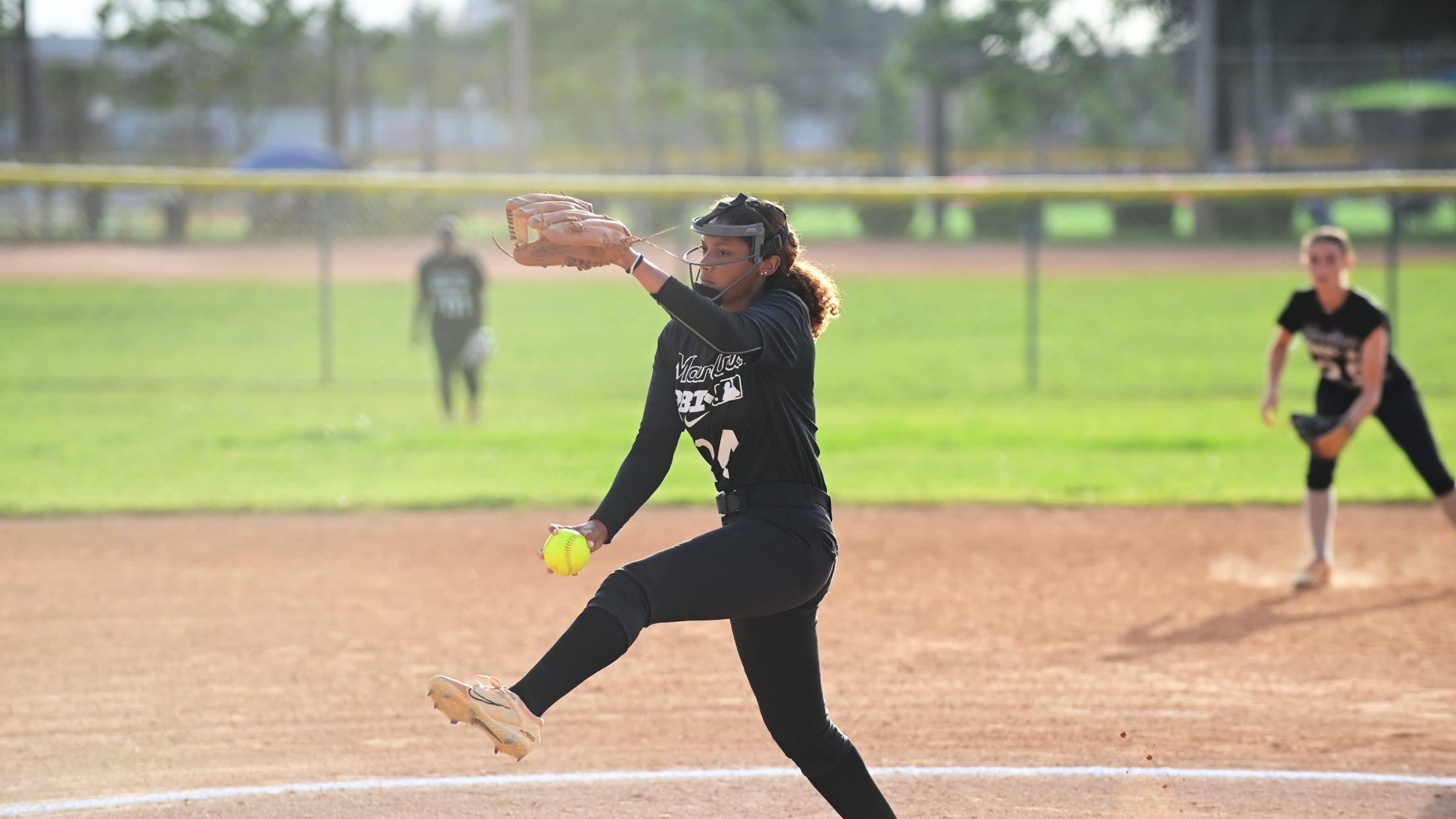 The softball pitcher winds up to throw her next pitch.
