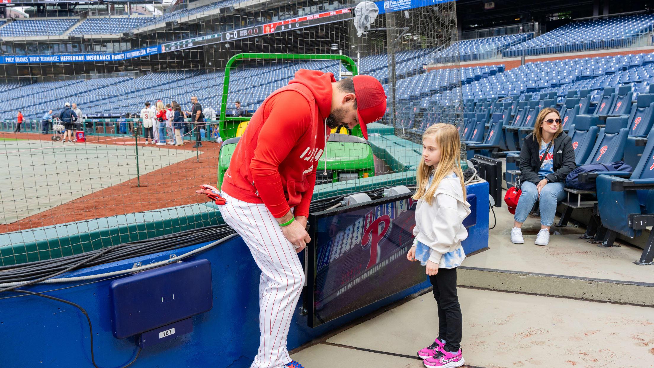 Kyle Schwarber signs a baseball for a young fan at Citizens Bank Park.
