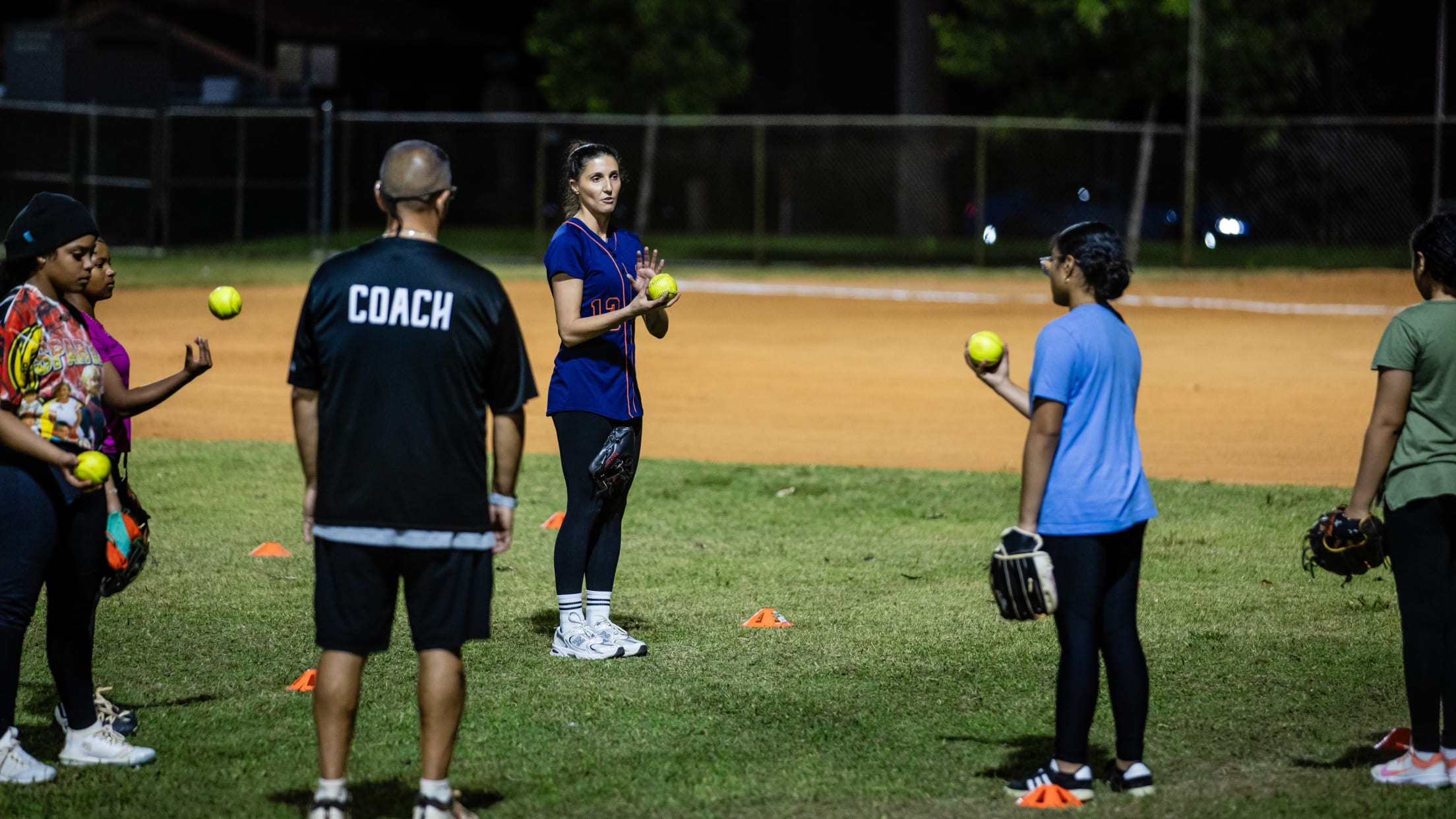 Coaches go over a softball drill with their players.