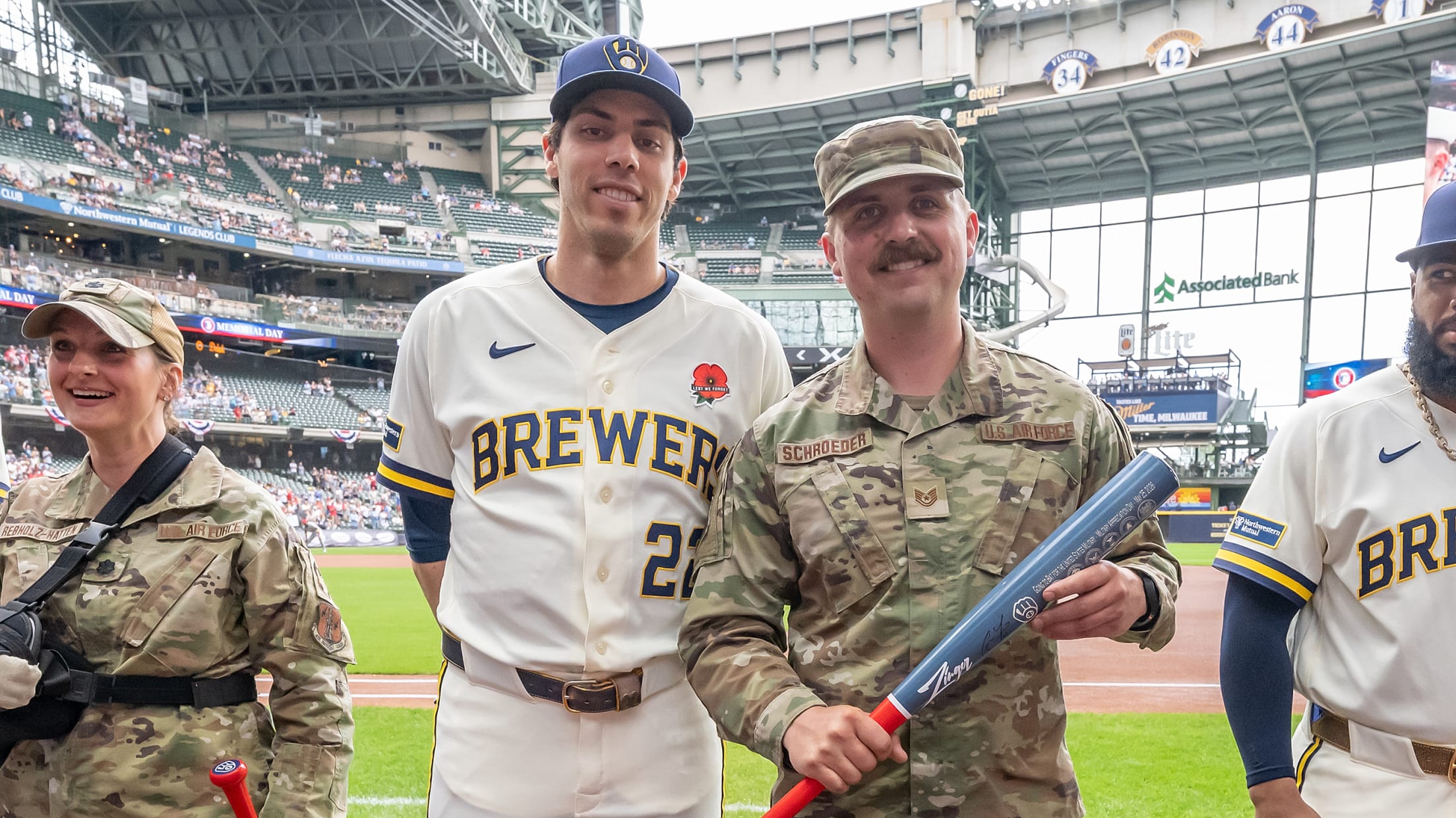 Christian Yelich takes a picture with a United States service member at American Family Field.
