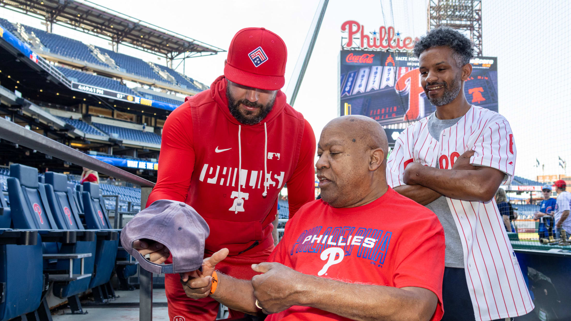 Kyle Schwarber signs a cap for a fan at Citizens Bank Park.