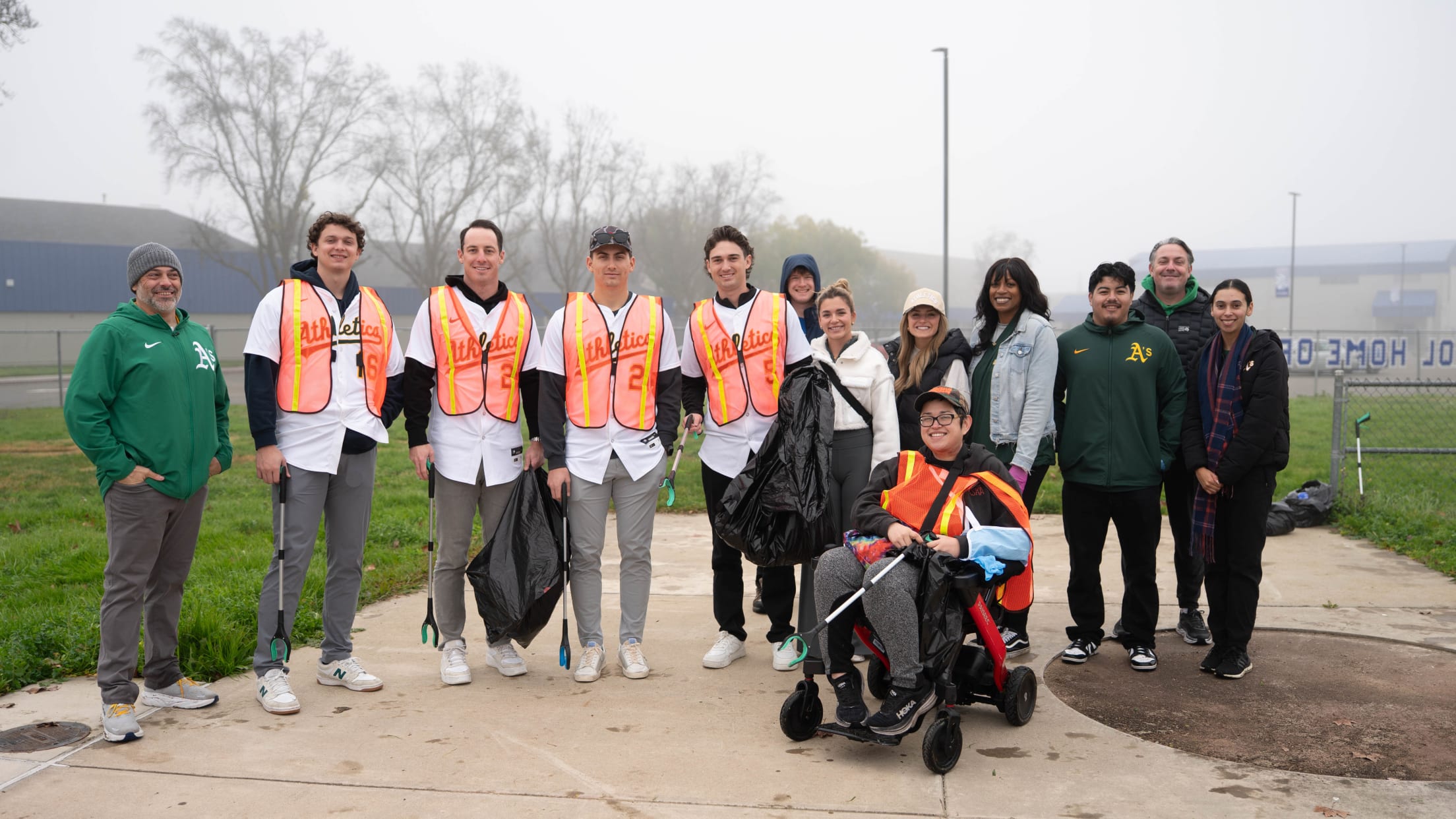 Athletics volunteer pose at an event where they picked up trash.