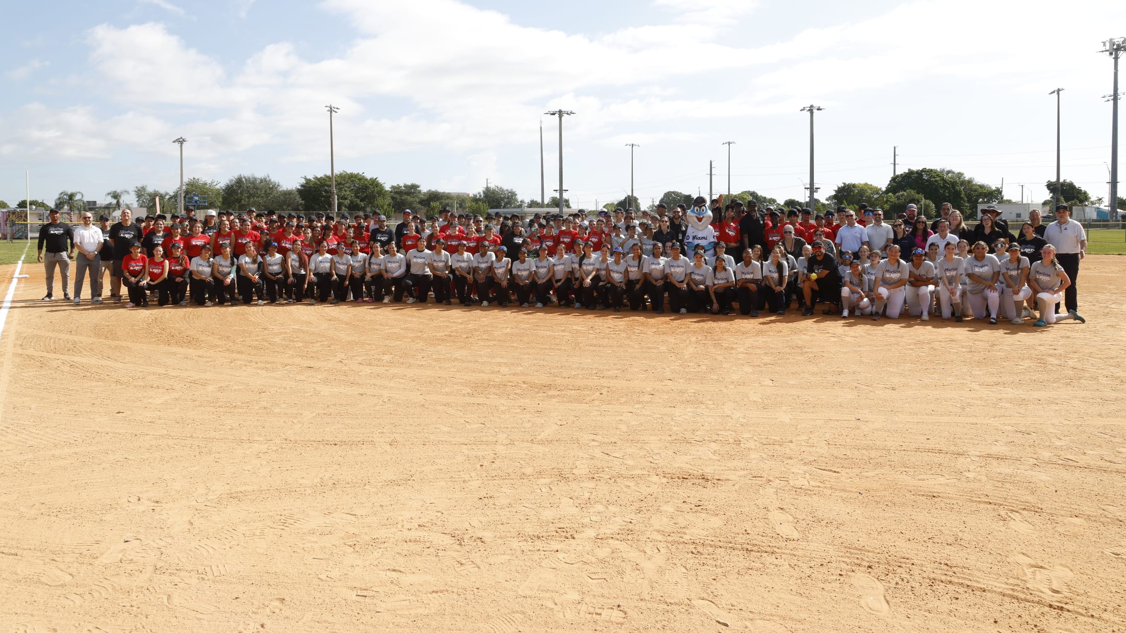 Players and coaches pose for a photo on the infield dirt of the Marlins NIke RBI Opening Day.