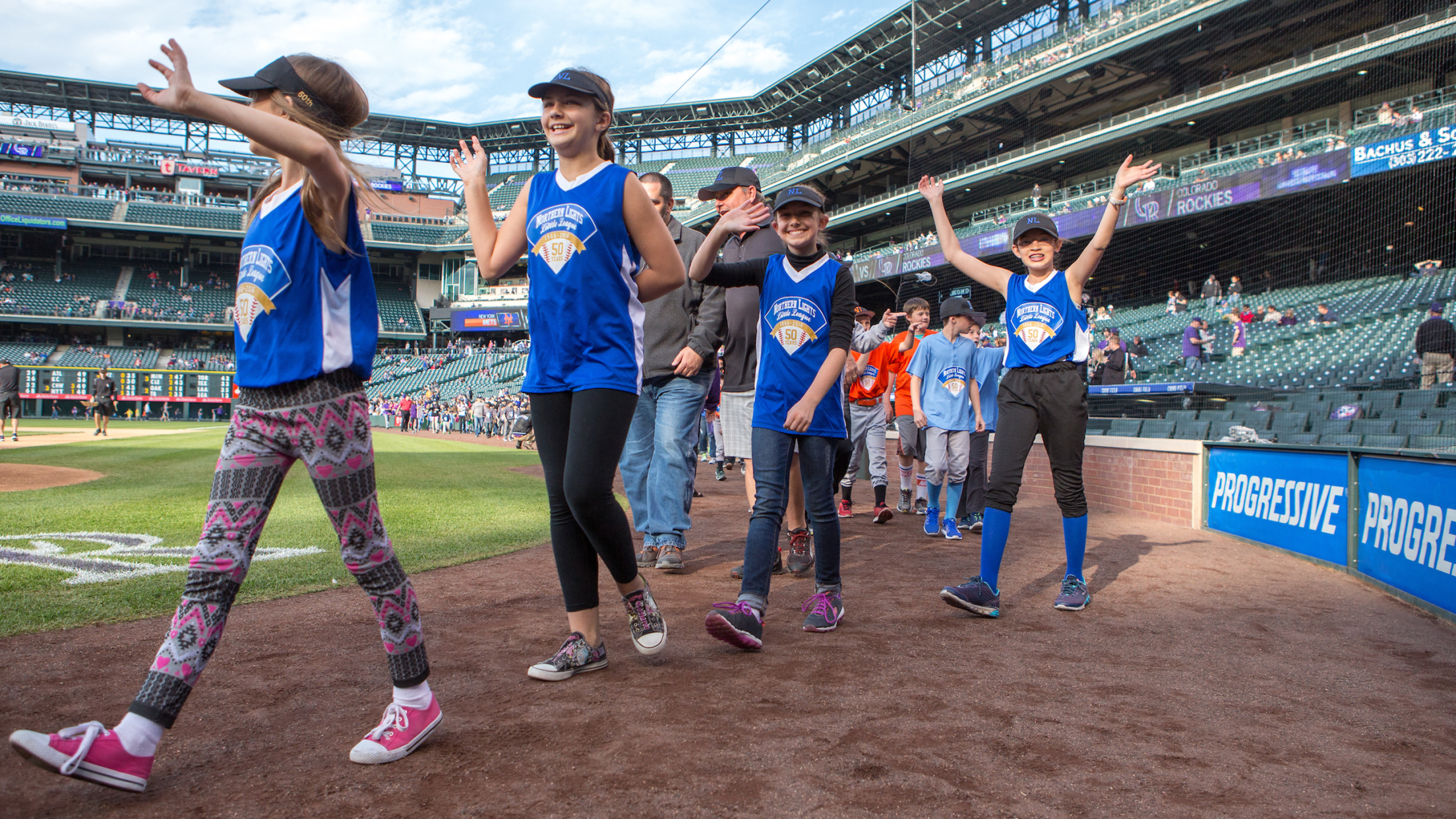 Pregame parade participants walking around Coors Field Warning Track