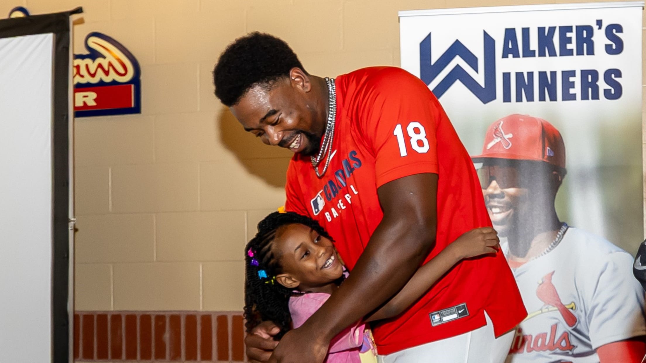 Jordan Walker embraces a young girl at a Walker's Winner's event.