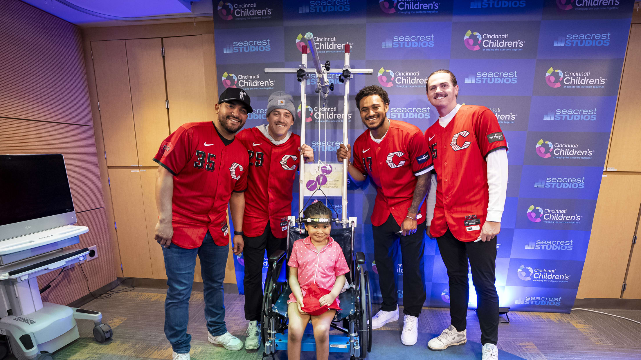 Jose Trevino and teammates take a picture with a young child at the Children's Hospital.