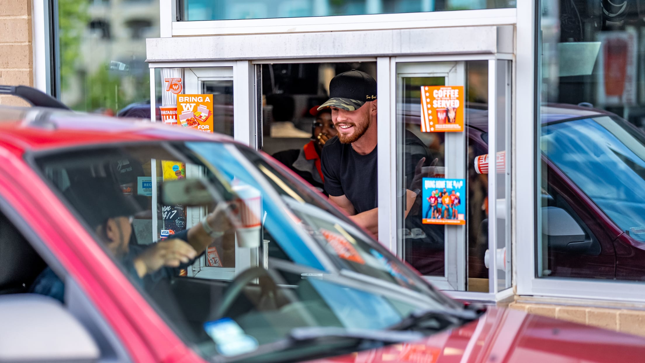 Bobby Witt Jr. helps workers at a Whataburger drive thru.