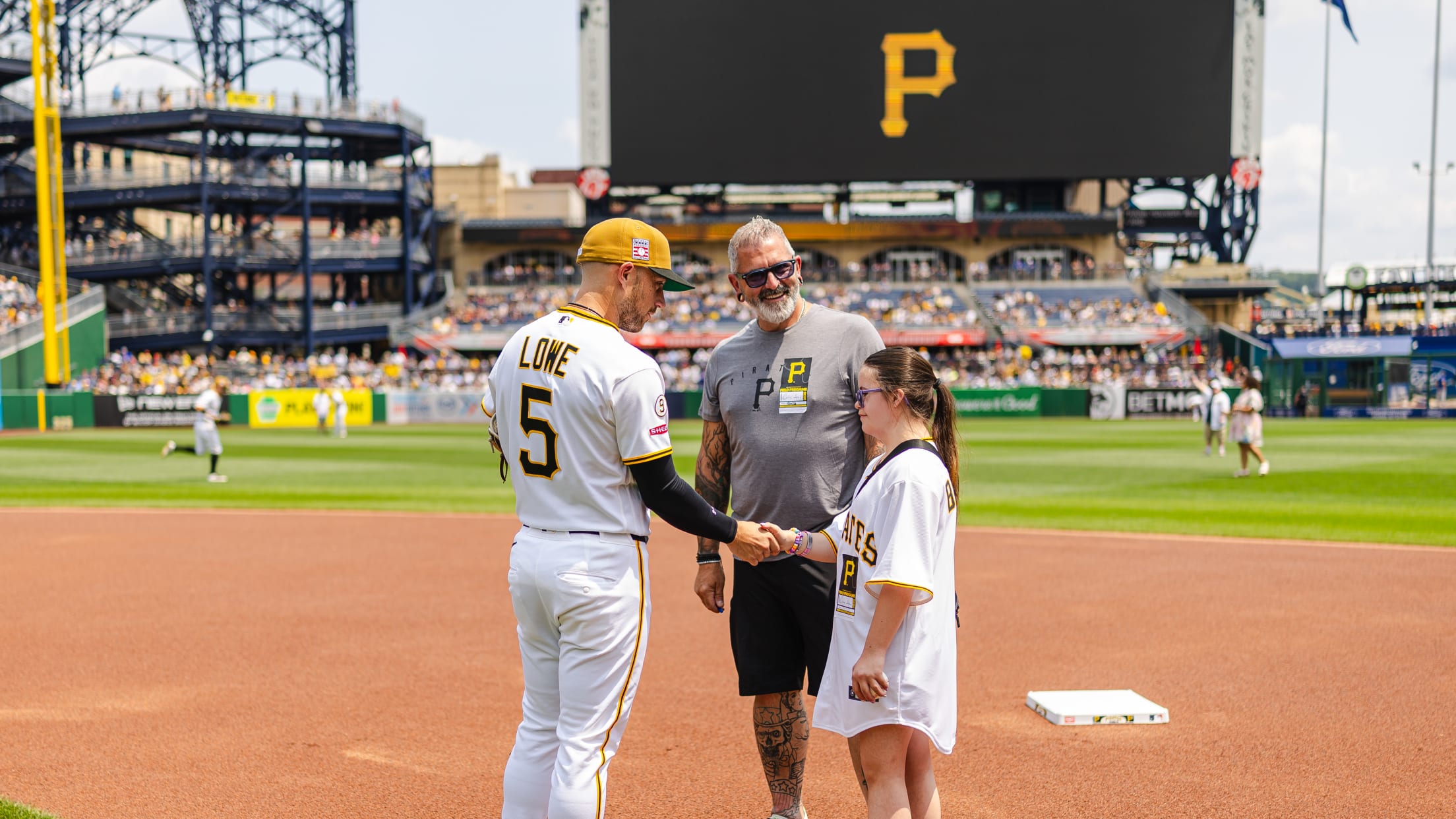 Brandon Lowe shakes hands with a Pittsburgh Pirates fan on the field at PNC Park.