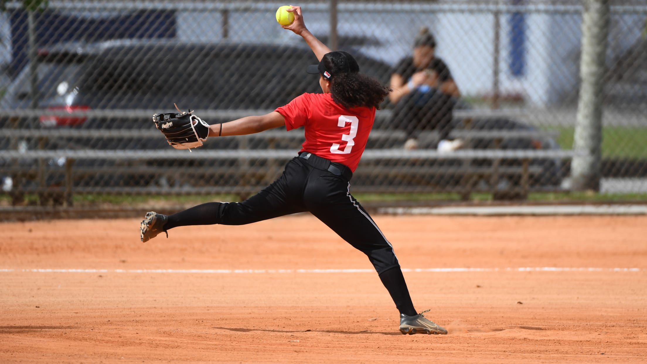 A softball pitcher winds up to throw the ball at Marlins Nike RBI Opening Day.