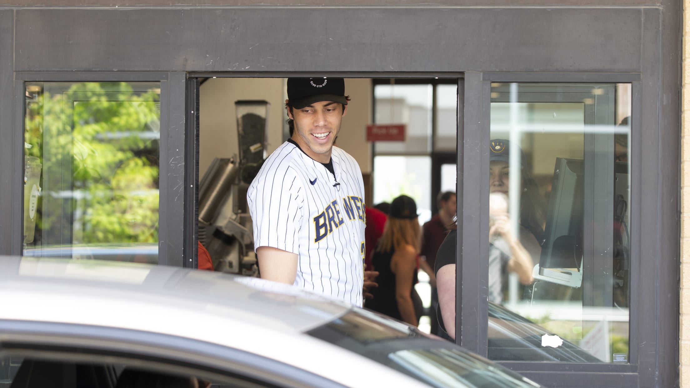 Christian Yelich interacts with a customer at the drive thru at Chick-fil-A.