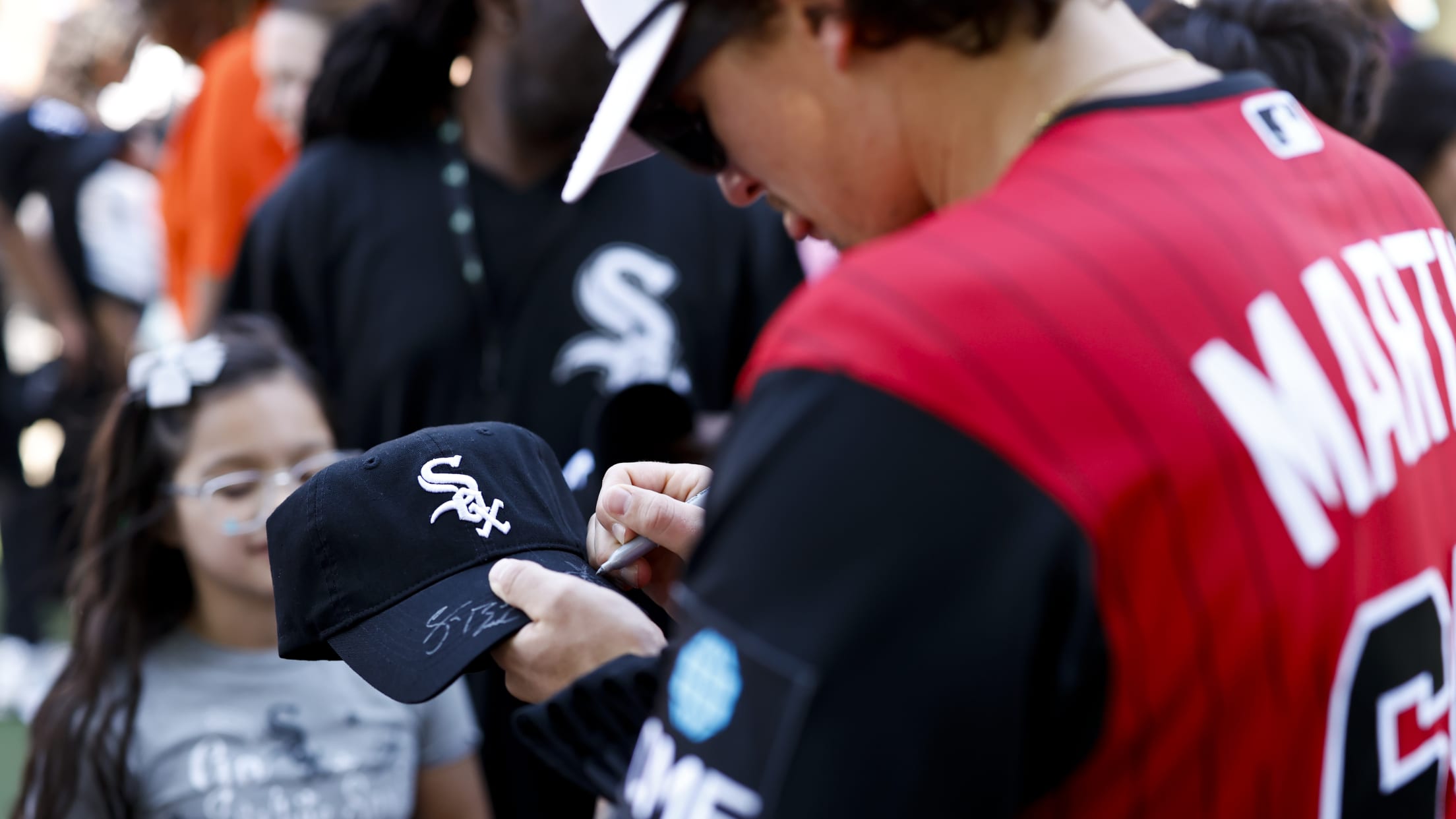 Davis Martin signs a Chicago White Sox hat for fans.
