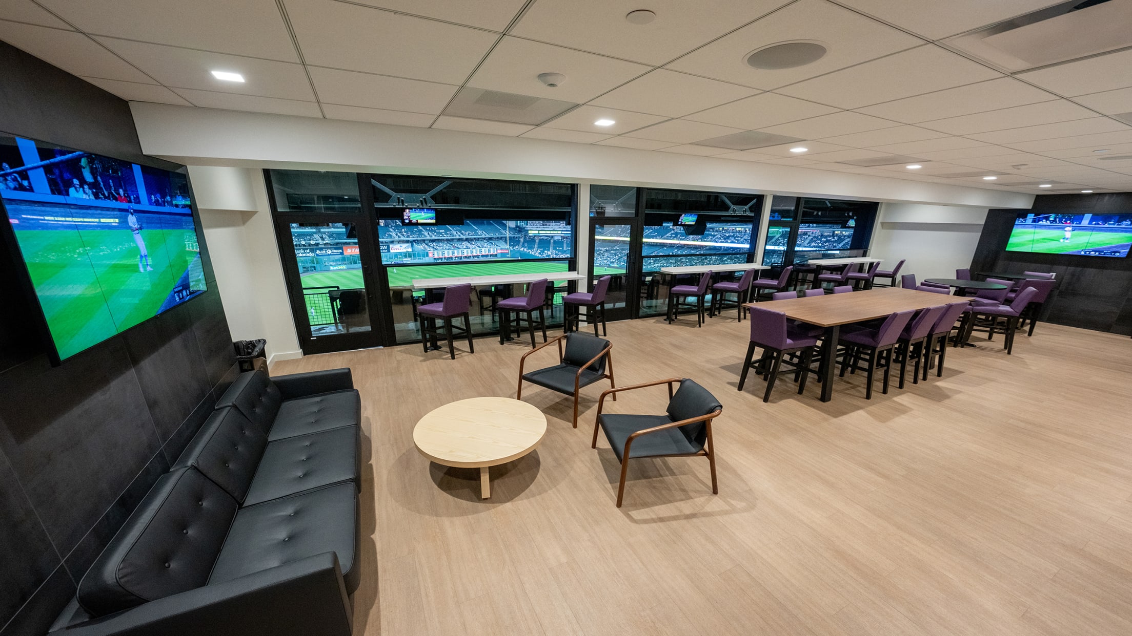 Inside of our newly renovated party summit suite with furniture, drink rails, and balcony seating