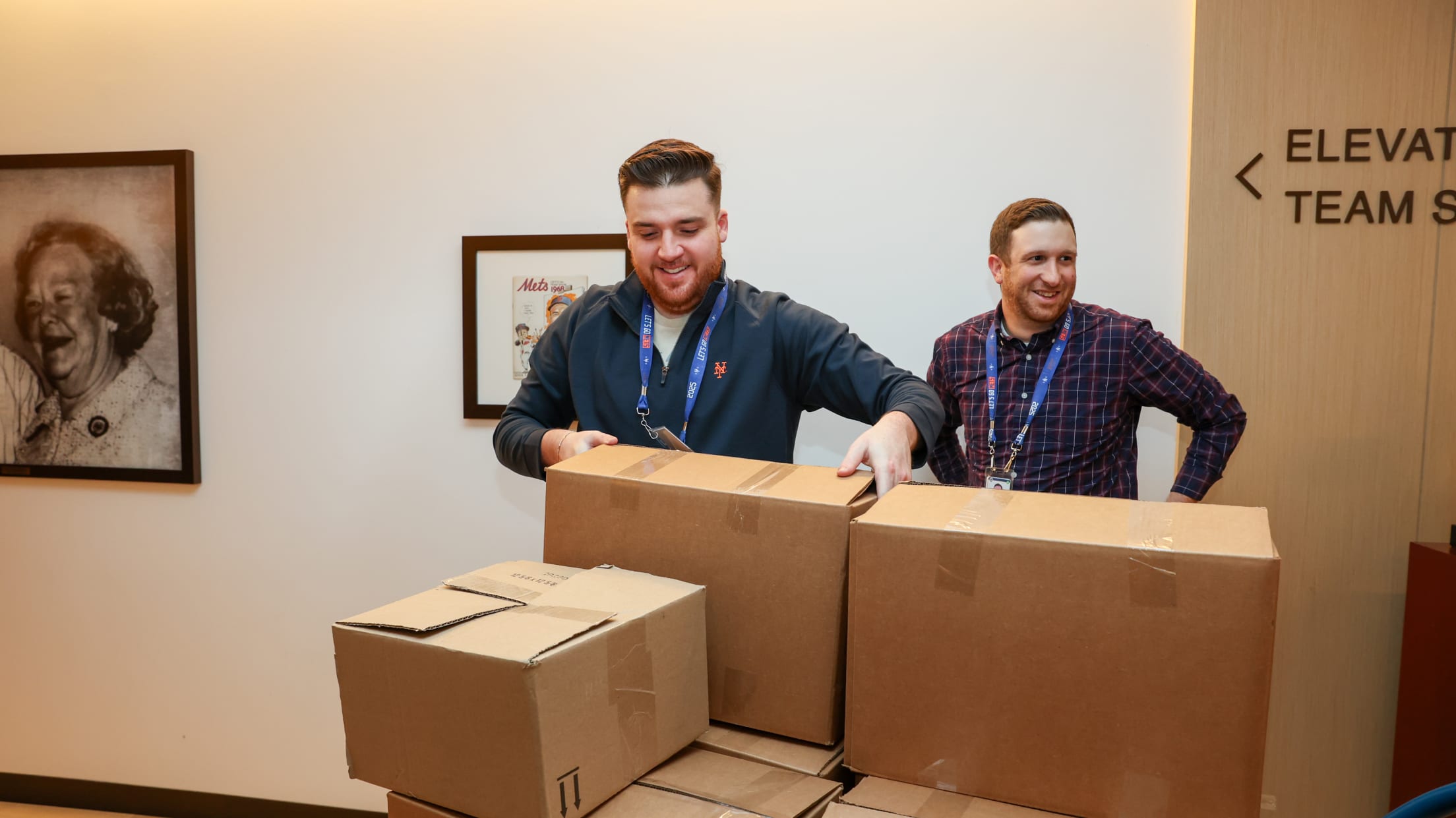 Volunteers with the Mets pick up boxed goods.