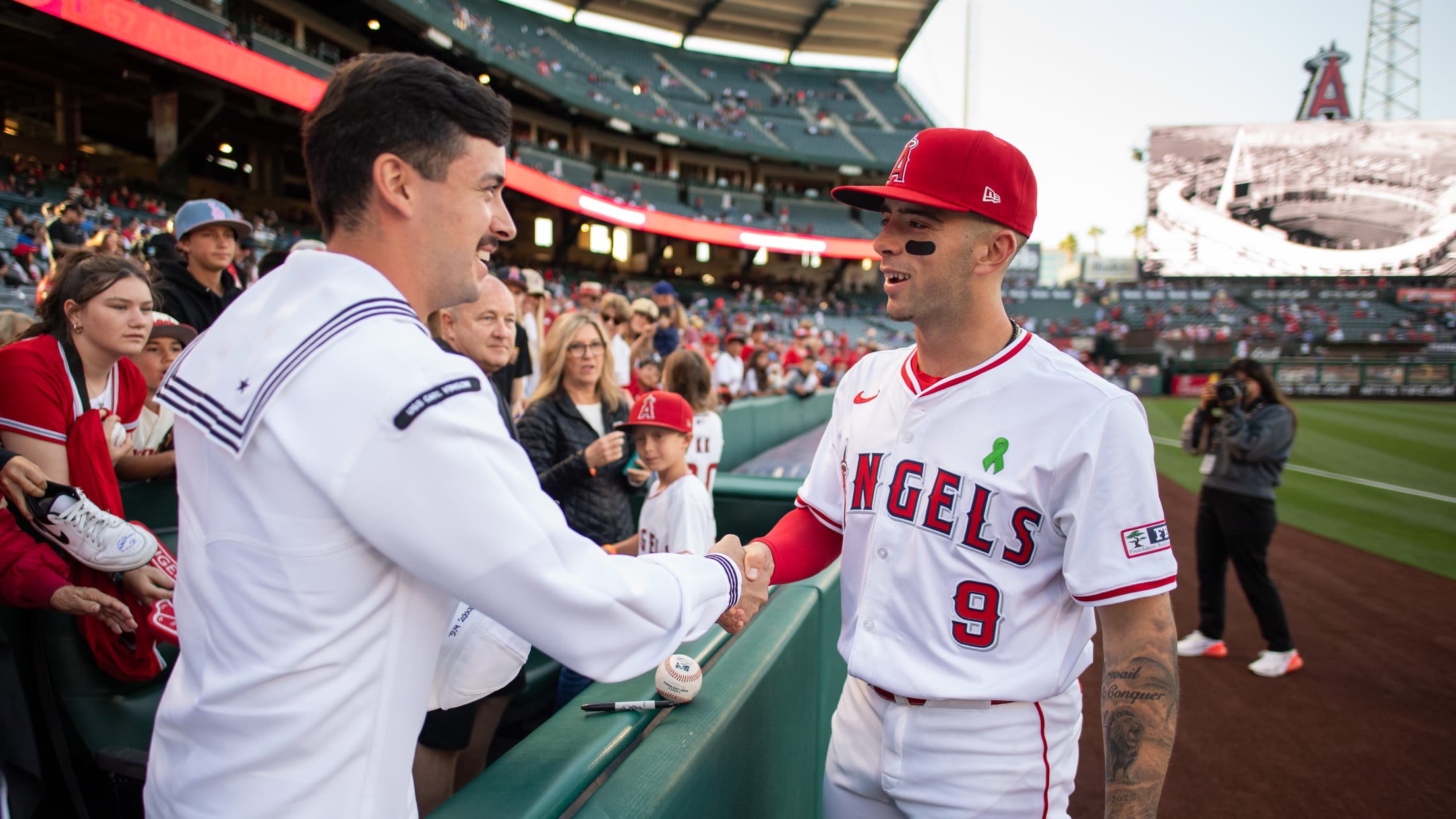 Zach Neto meets with a United States service member in the stands of Angel Stadium.