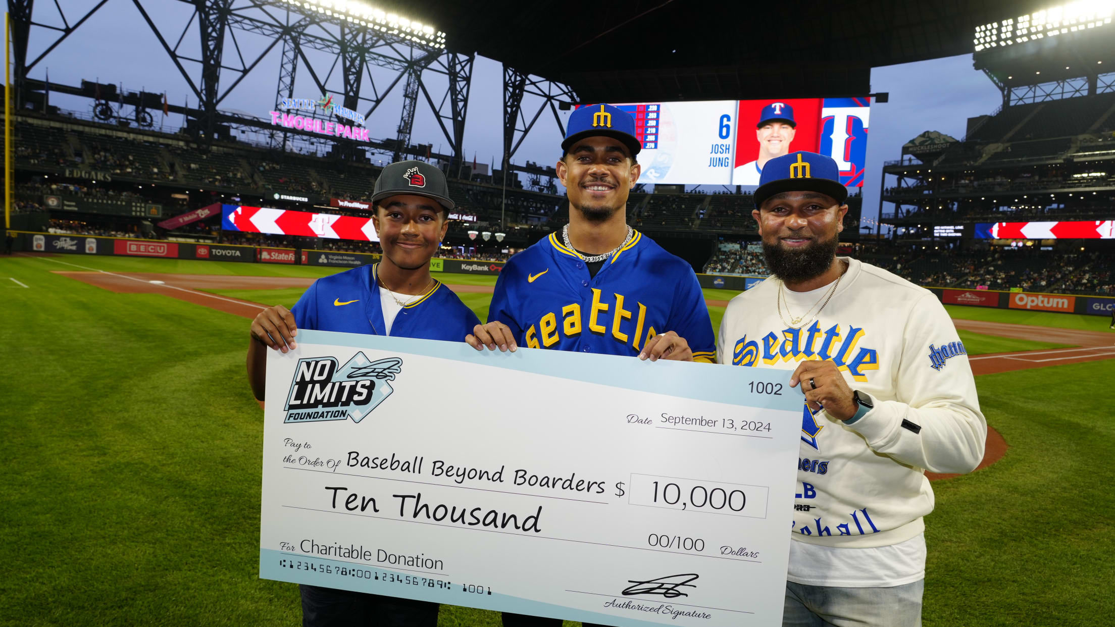 Julio Rodriguez hands a $10,000 check to Baseball Beyond Boarders.
