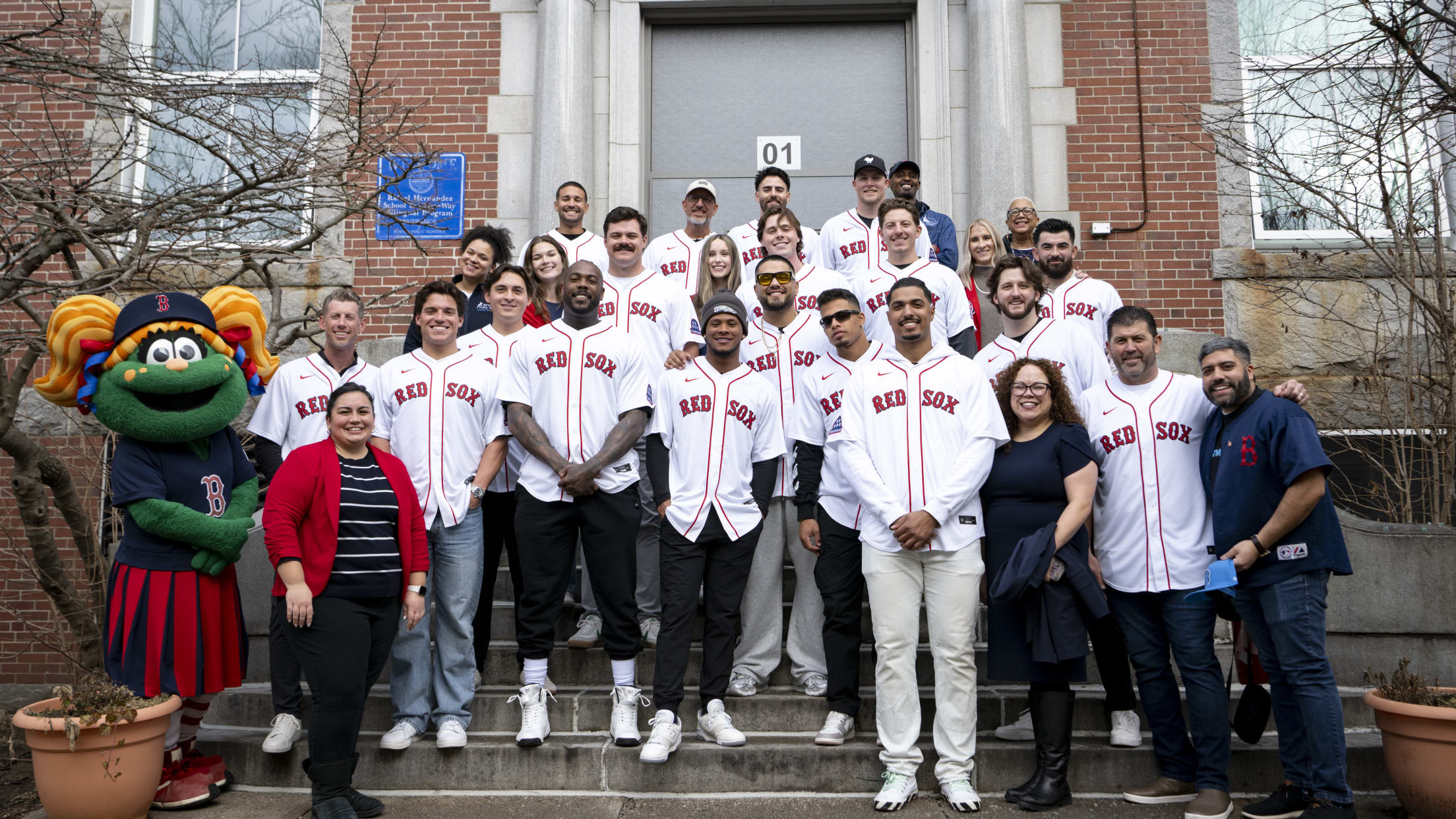 Volunteers in Red Sox jerseys pose with Tessie the Green Monster.