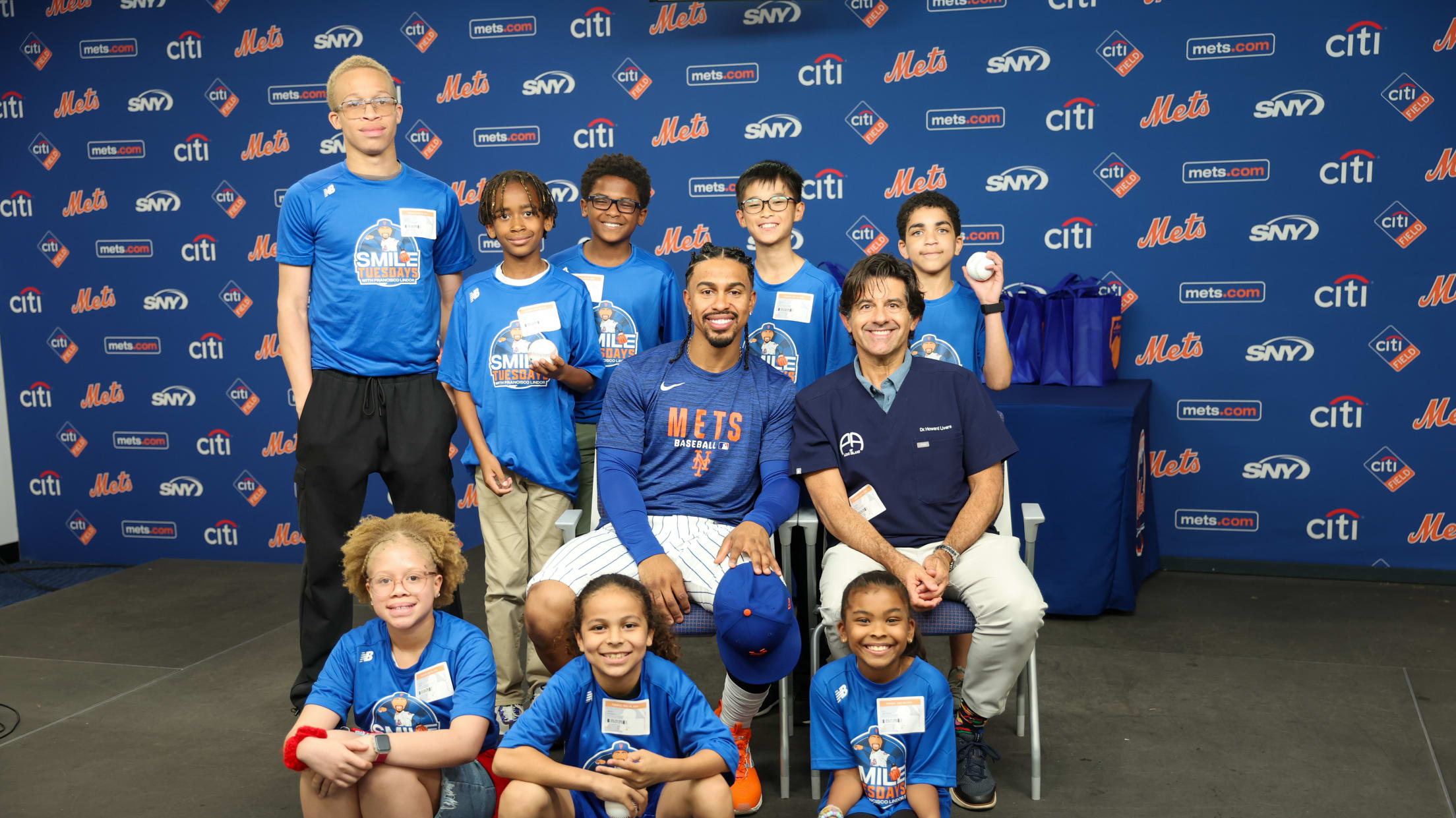 Francisco Lindor takes a photo with a group participating in Smile Tuesdays.