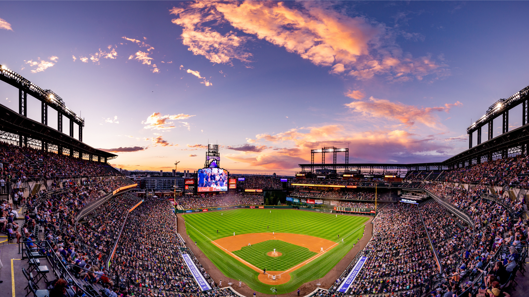 Coors Field during a game with sunset