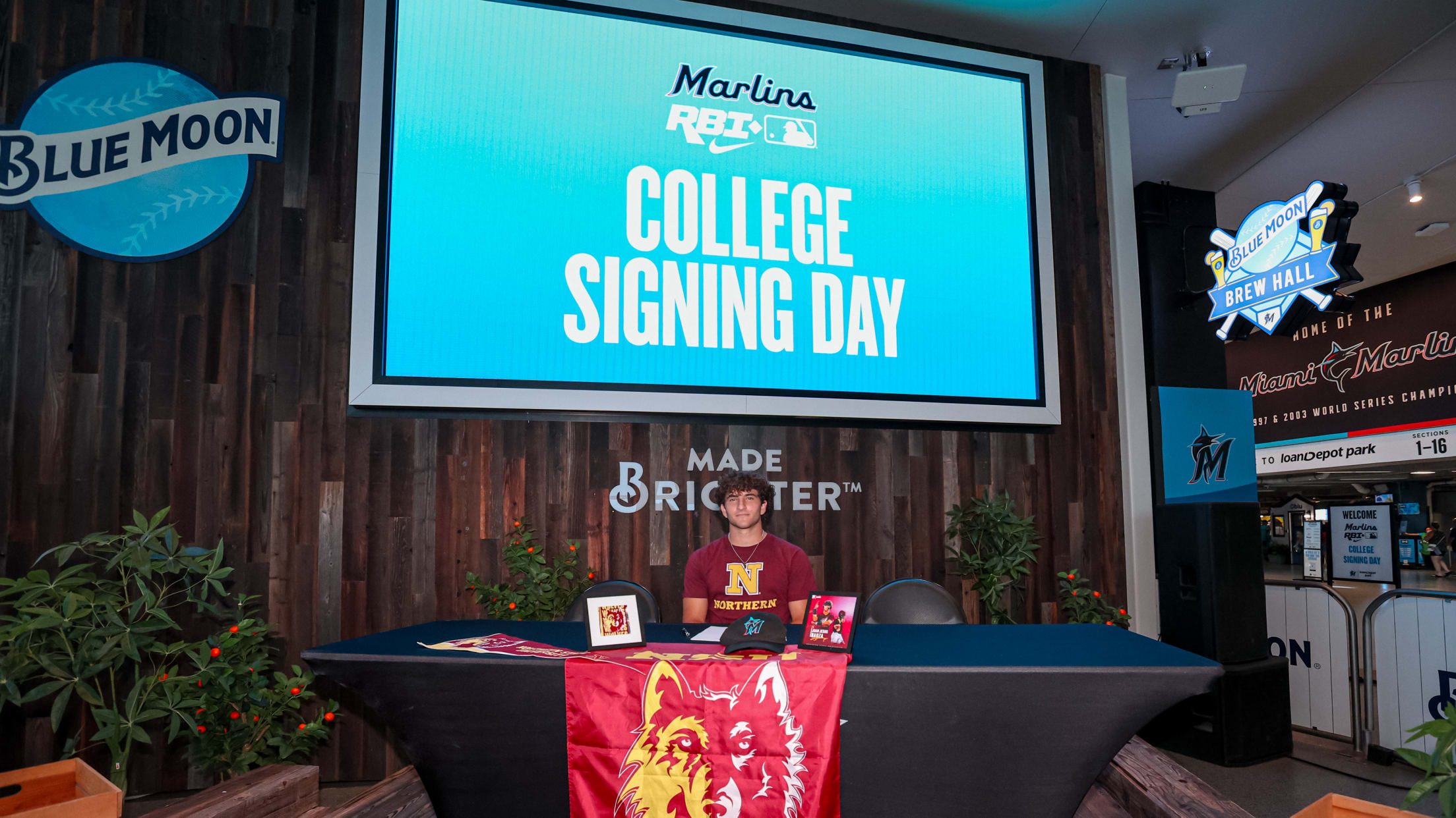 A player sits behind a Wolves banner at the Marlins Nike RBI College Signing Day.