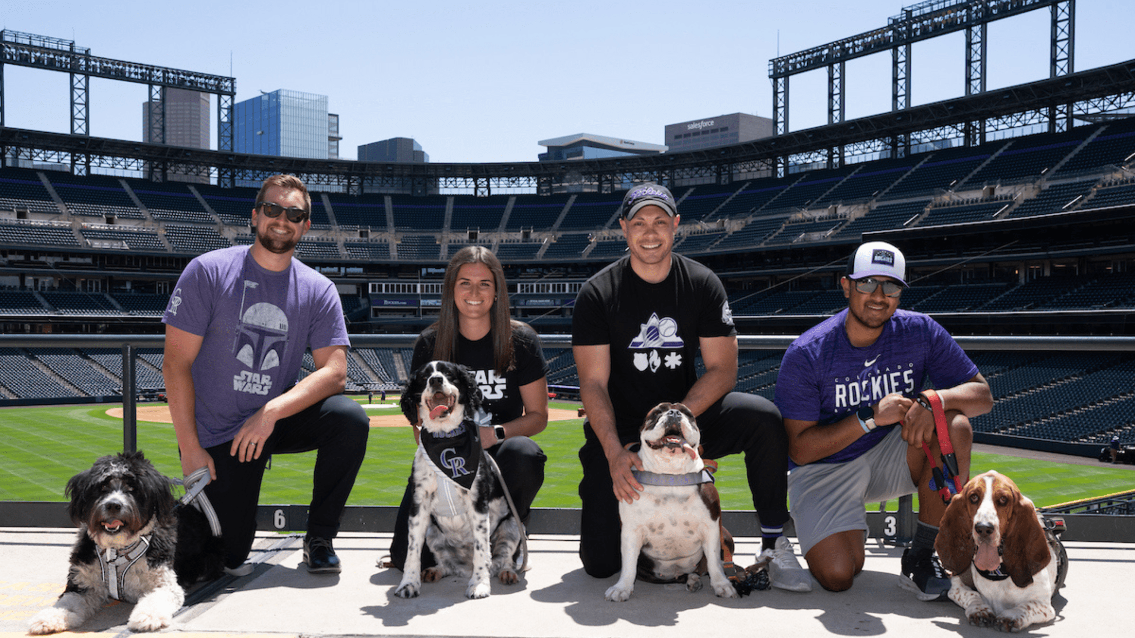 Four Rockies fans with their dogs at Coors Field.