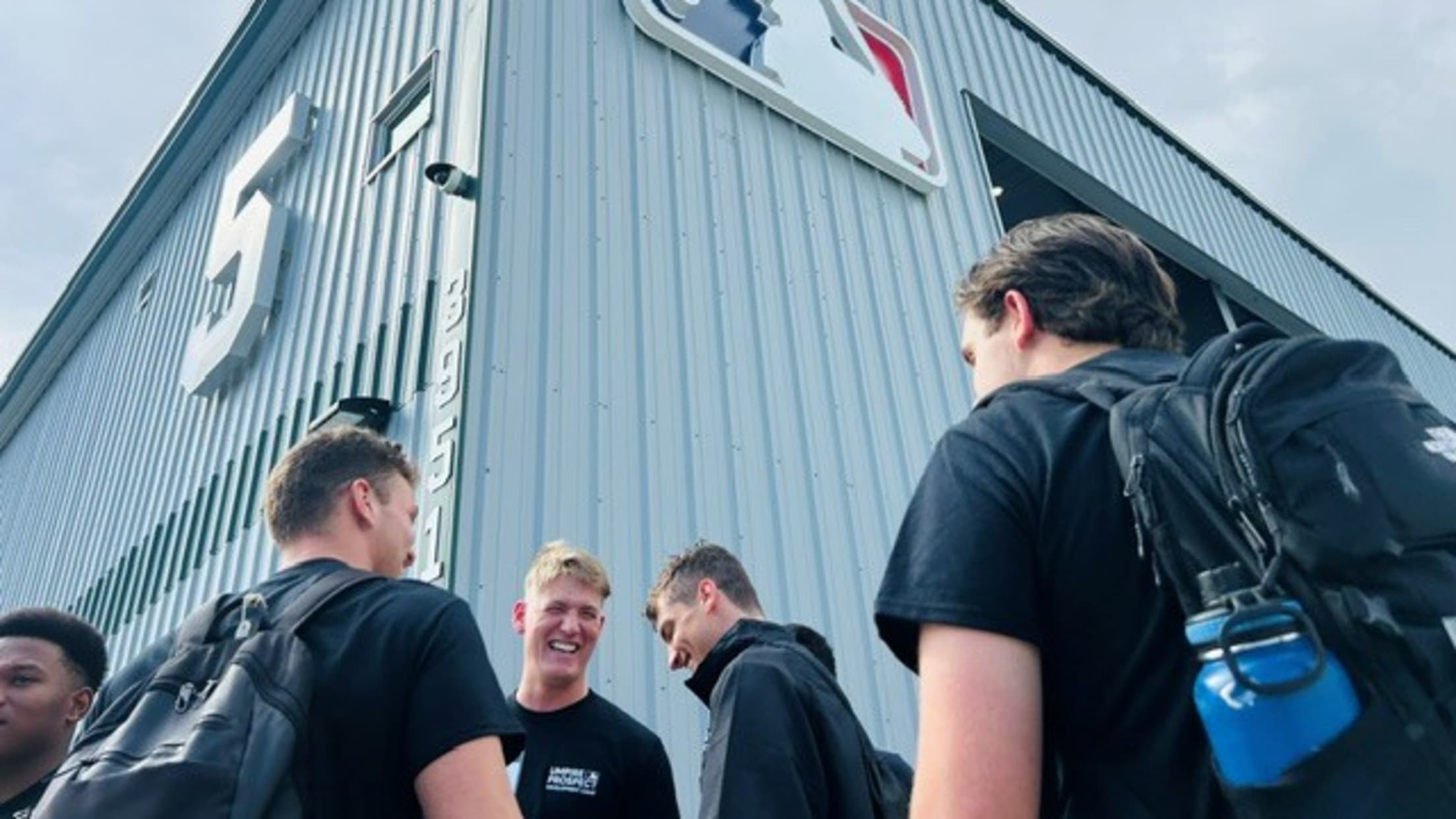 Umpire prospects converse outside the Robinson Training Complex.