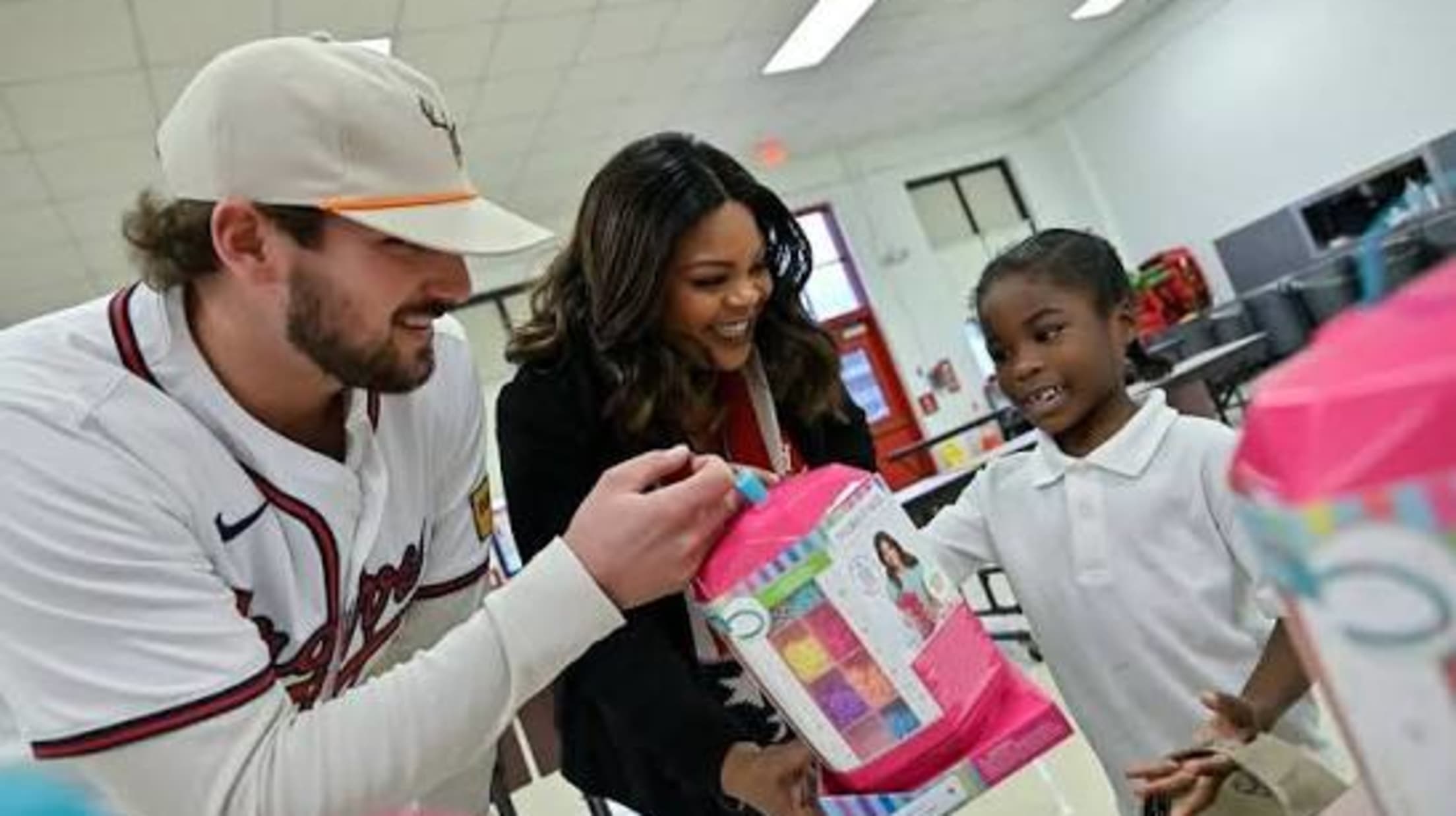 Austin Riley gifts a toy to a child at an event.