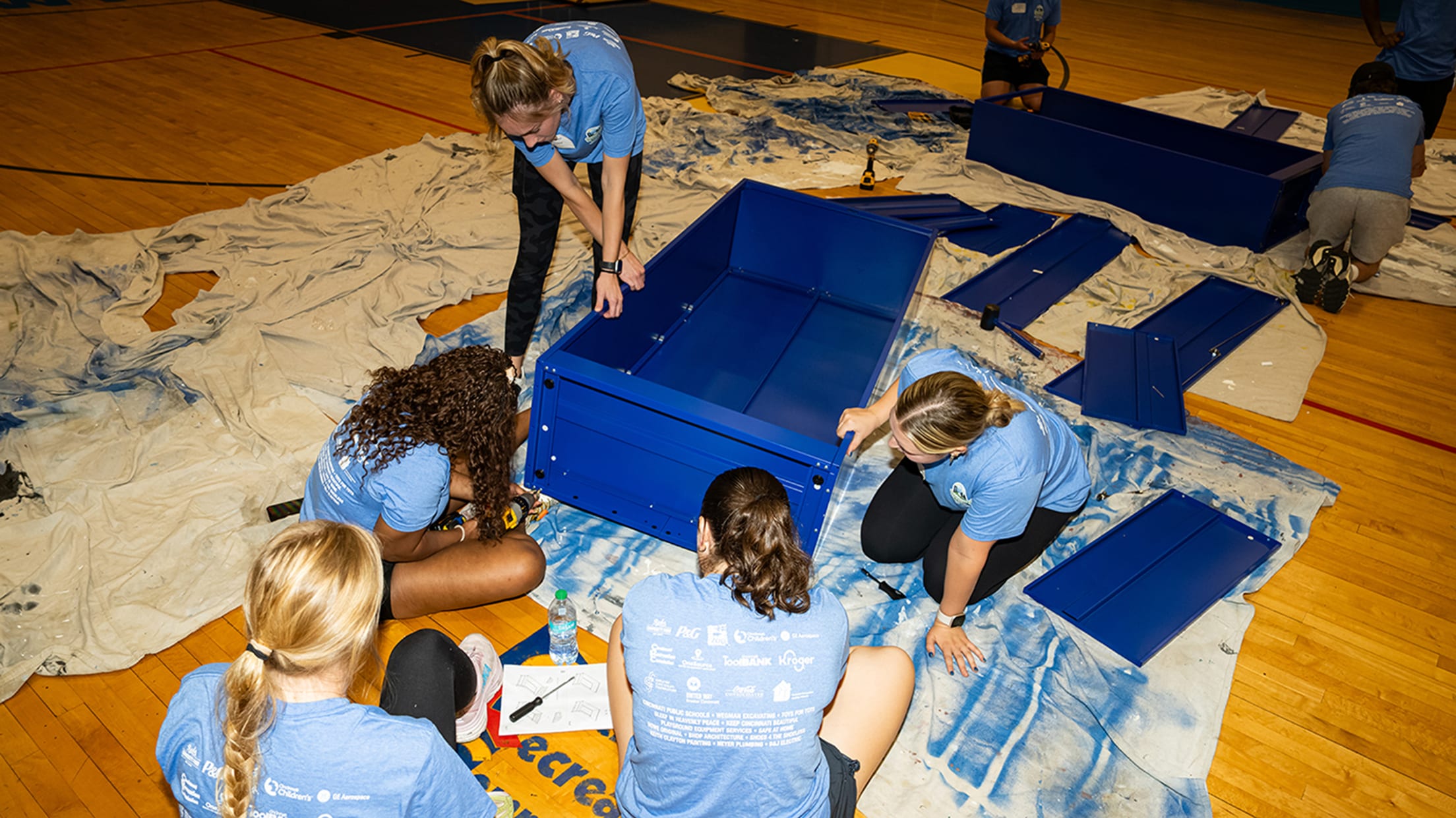 A group of volunteers working together inside the gymnasium.