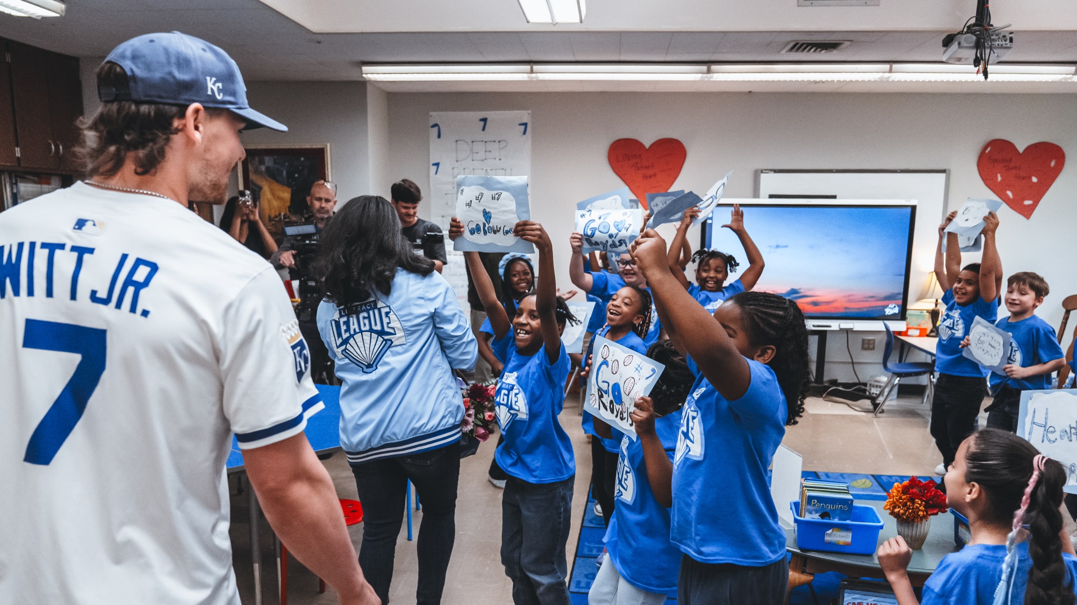 Bobby Witt Jr. meets excited fans as they welcome him with signs and cheers at an event.