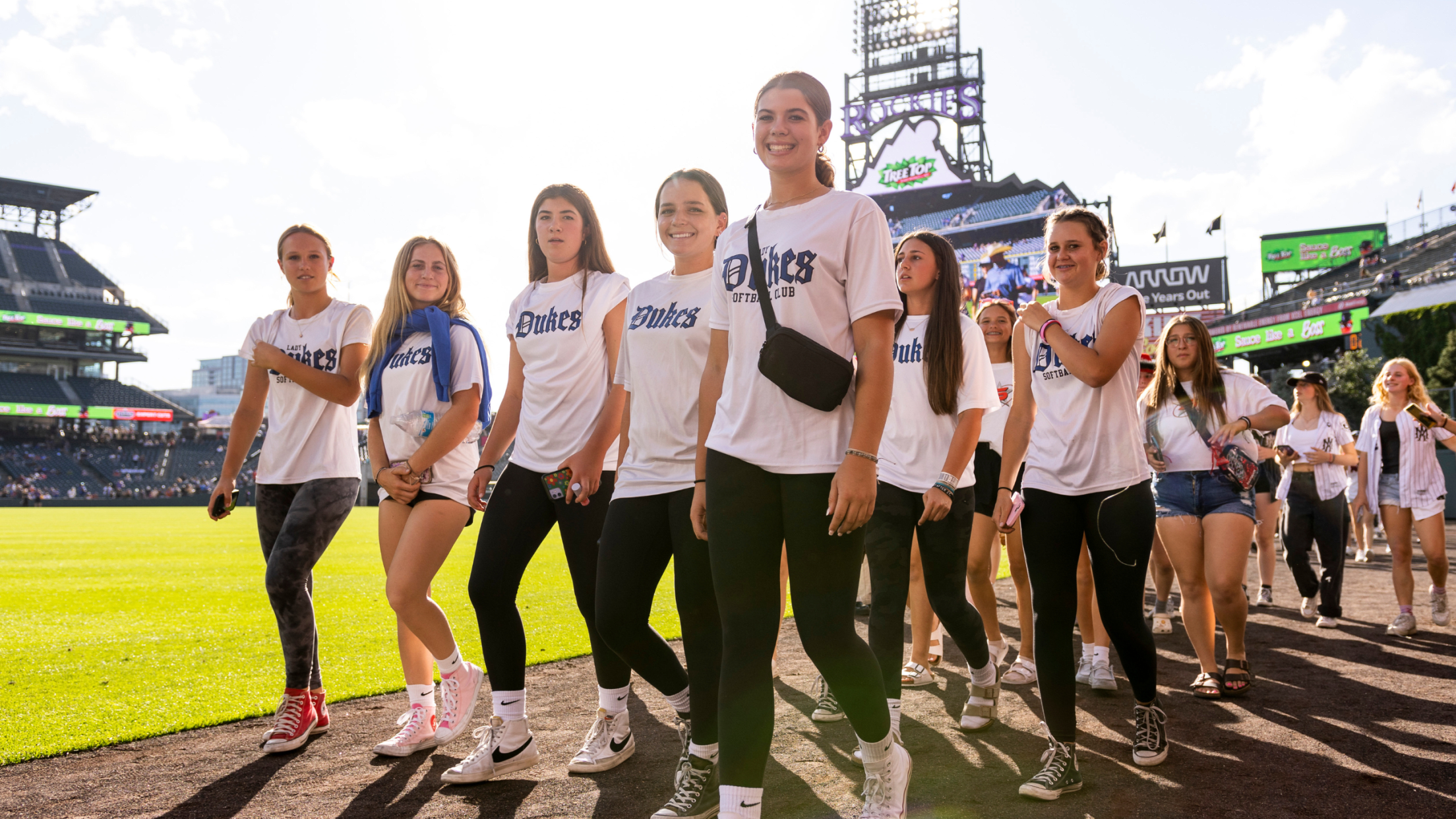 Pregame parade participants walking around Coors Field Warning Track