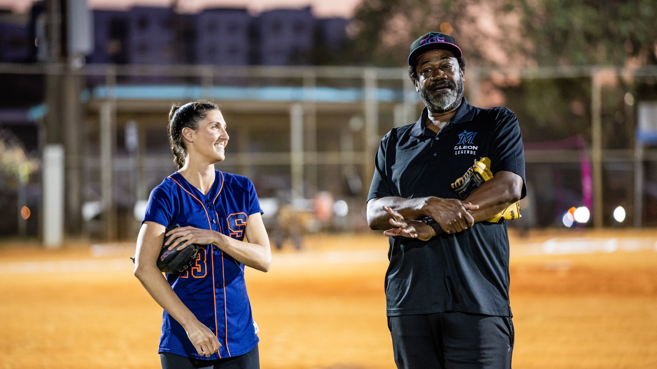 Coaches stand on the baseball field and talk to their players during the Marlins Nike RBI Winter Development Clinic.
