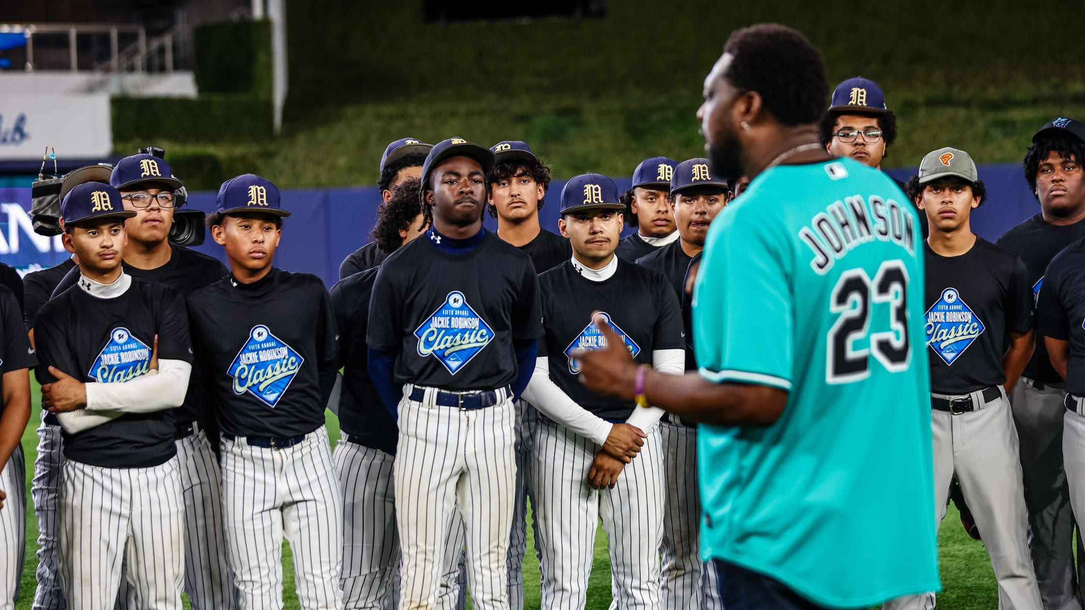 Former Marlins catcher Charles Johnson speaks to players at the Jackie Robinson Classic.