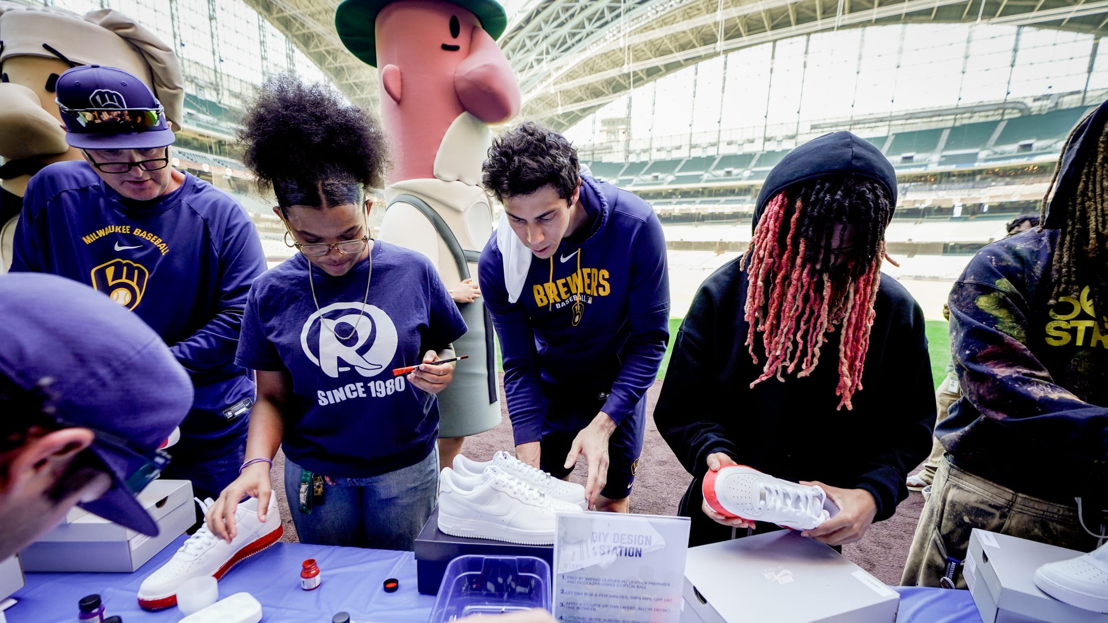 Christian Yelich colors shoes with kids at an event at American Family Field.