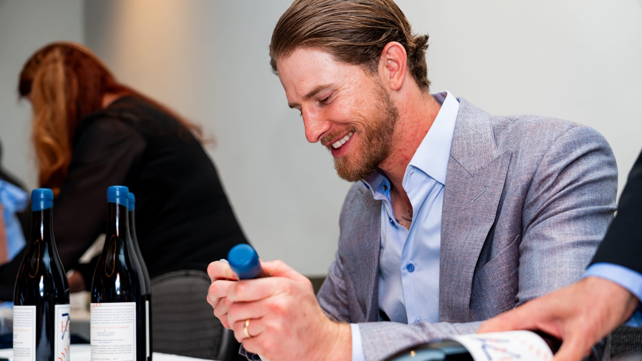 Josh Hader signs wine bottles at an event for Uncork for a Cause.