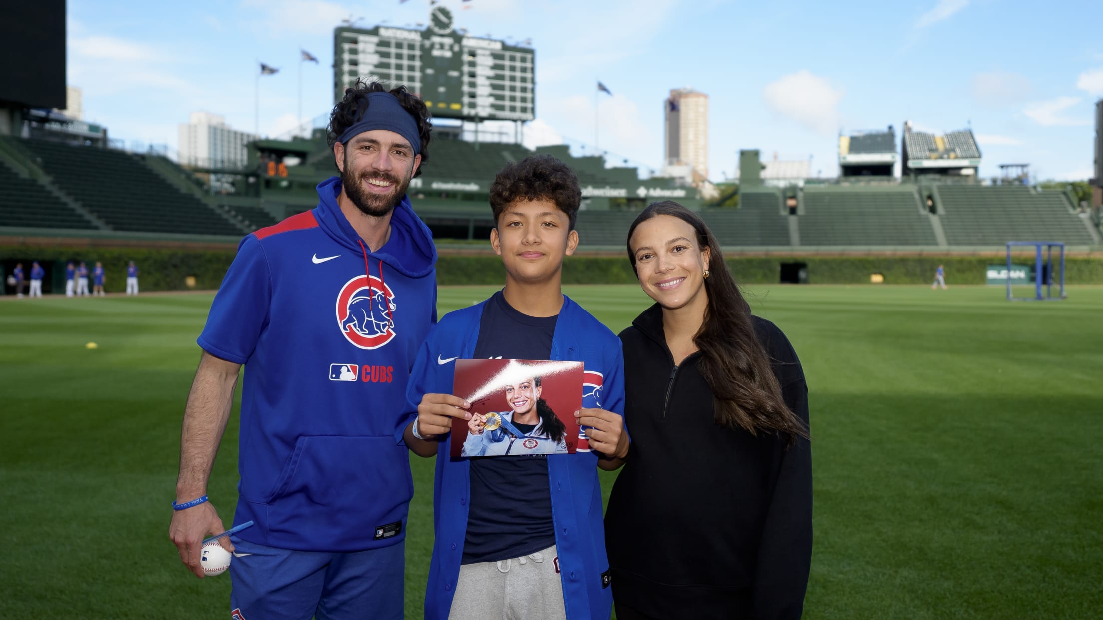 Dansby Swanson and Mallory Pugh Swanson pose with a Chicago Cubs fan at Wrigley Field.
