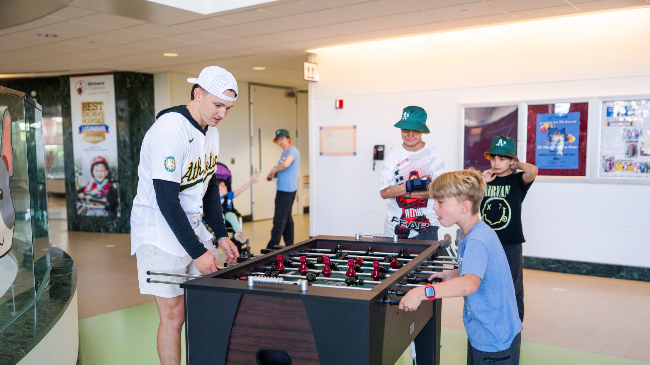 Zack Gelof plays foosball with a fan at Shriners Children's Hospital.