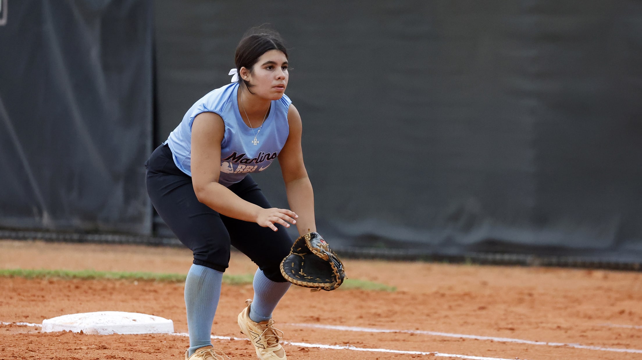 The softball player prepares for the next pitch as they get into fielding position.