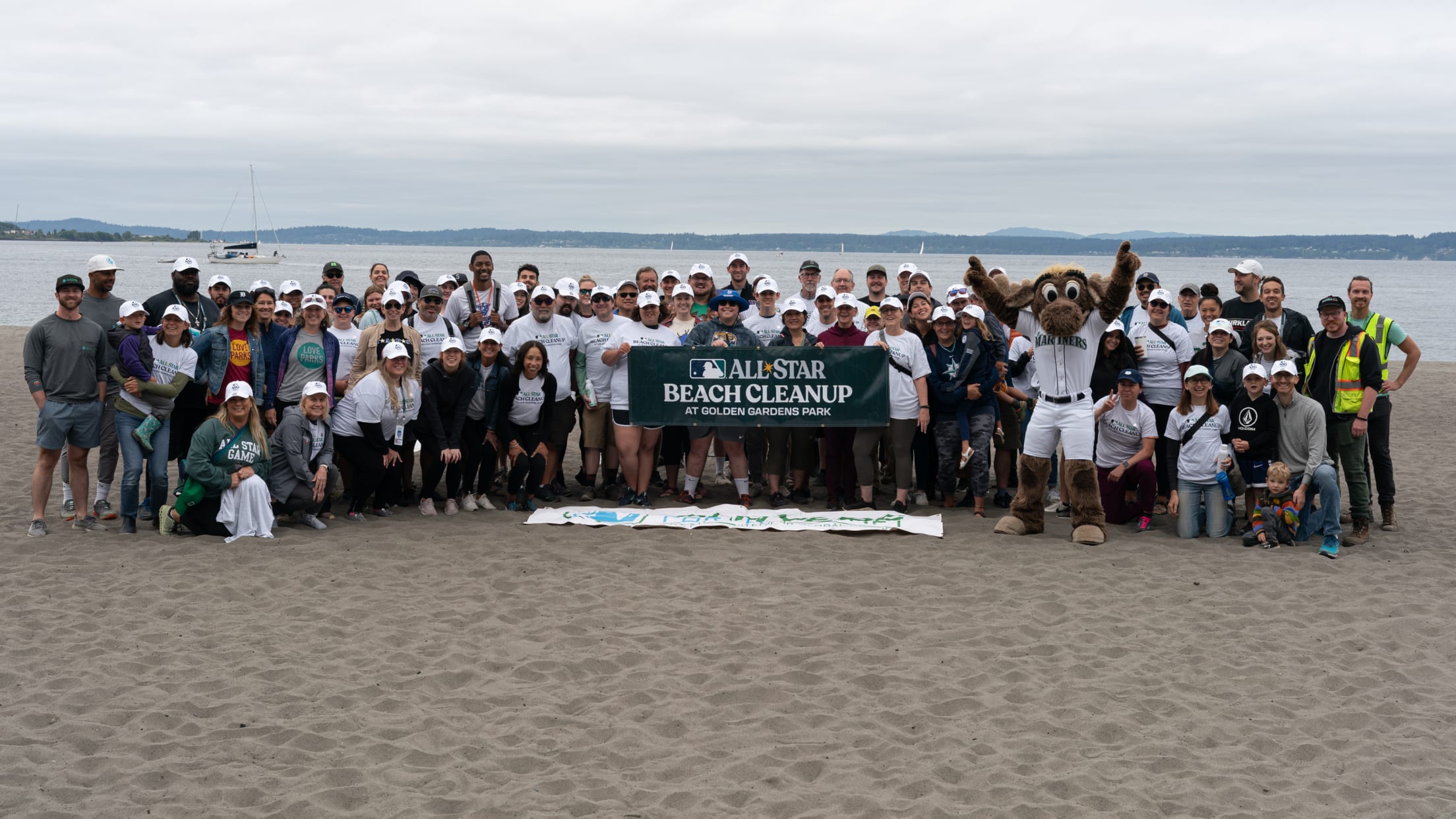 Volunteers gather at a beach in Golden Gardens Park in Seattle for a beach cleanup.