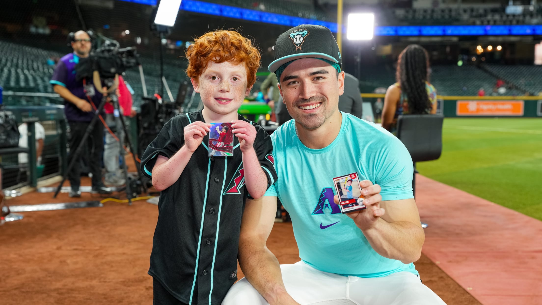 Corbin Carroll poses with a fan as they show off baseball cards.