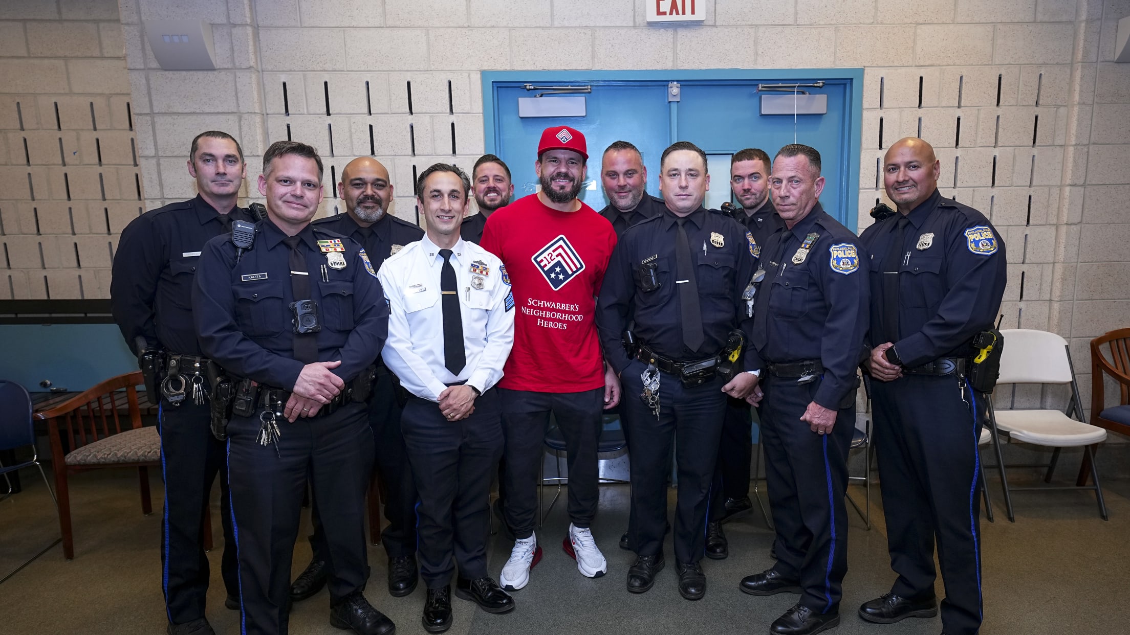 Kyle Schwarber takes a photo with police officers as he participates in Neighborhood Heroes.