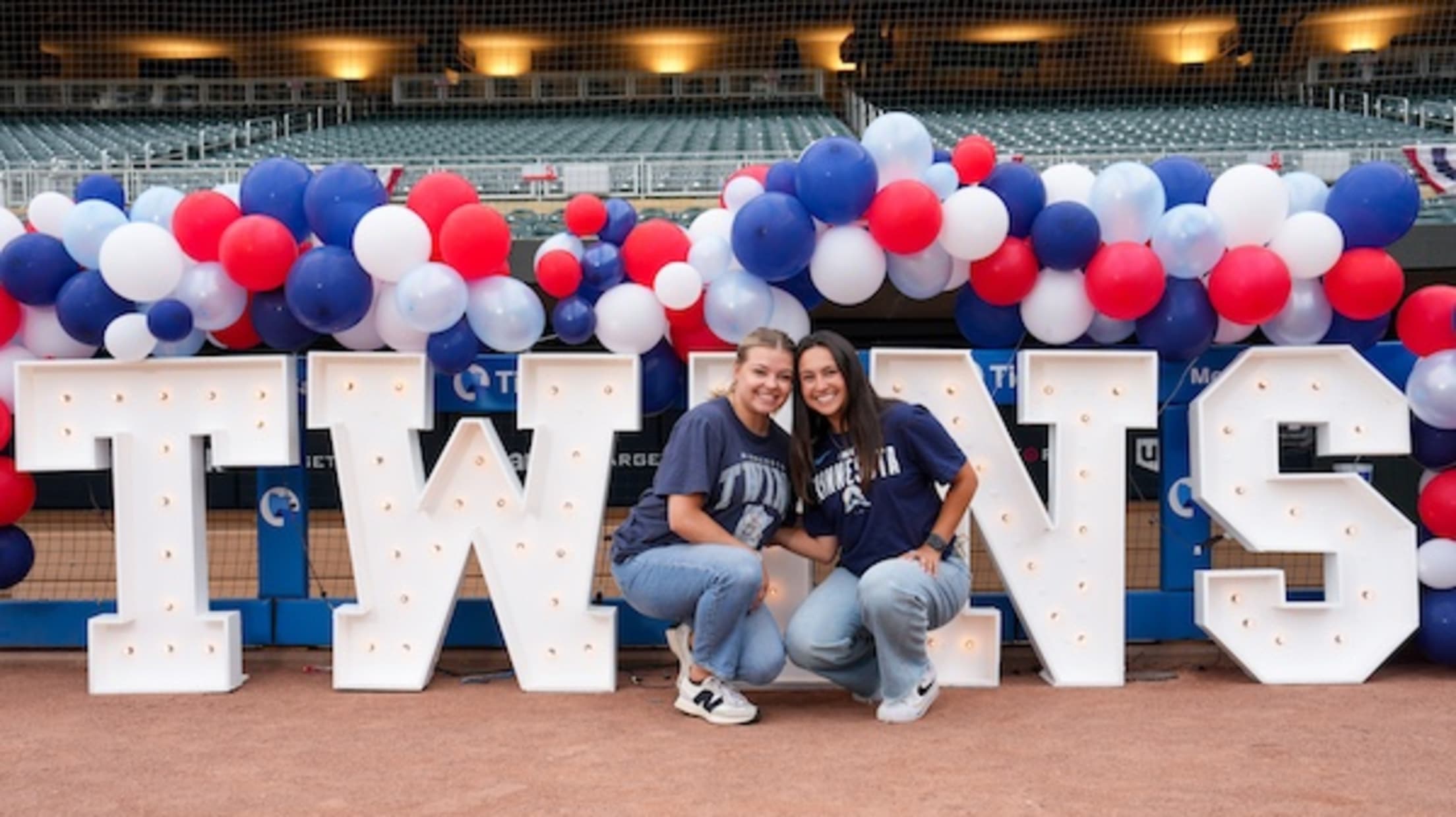 Twins Employees at Family Day in front of Big Twins sign and team-colored balloons