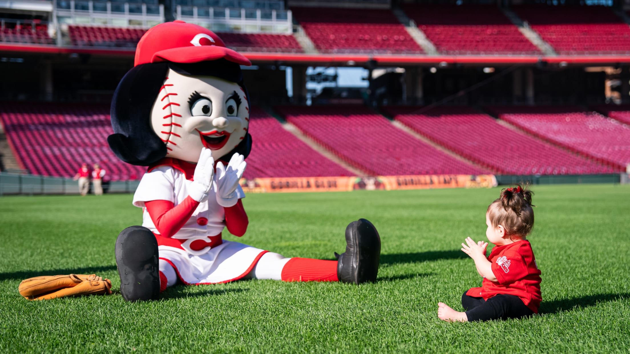Reds Rookies member and Rosie Red participating in Reds Rookies Catch & Crawl event at the ballpark.