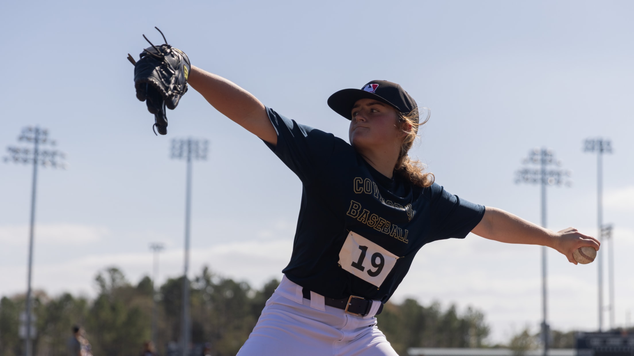 Young female player pitching in a softball game