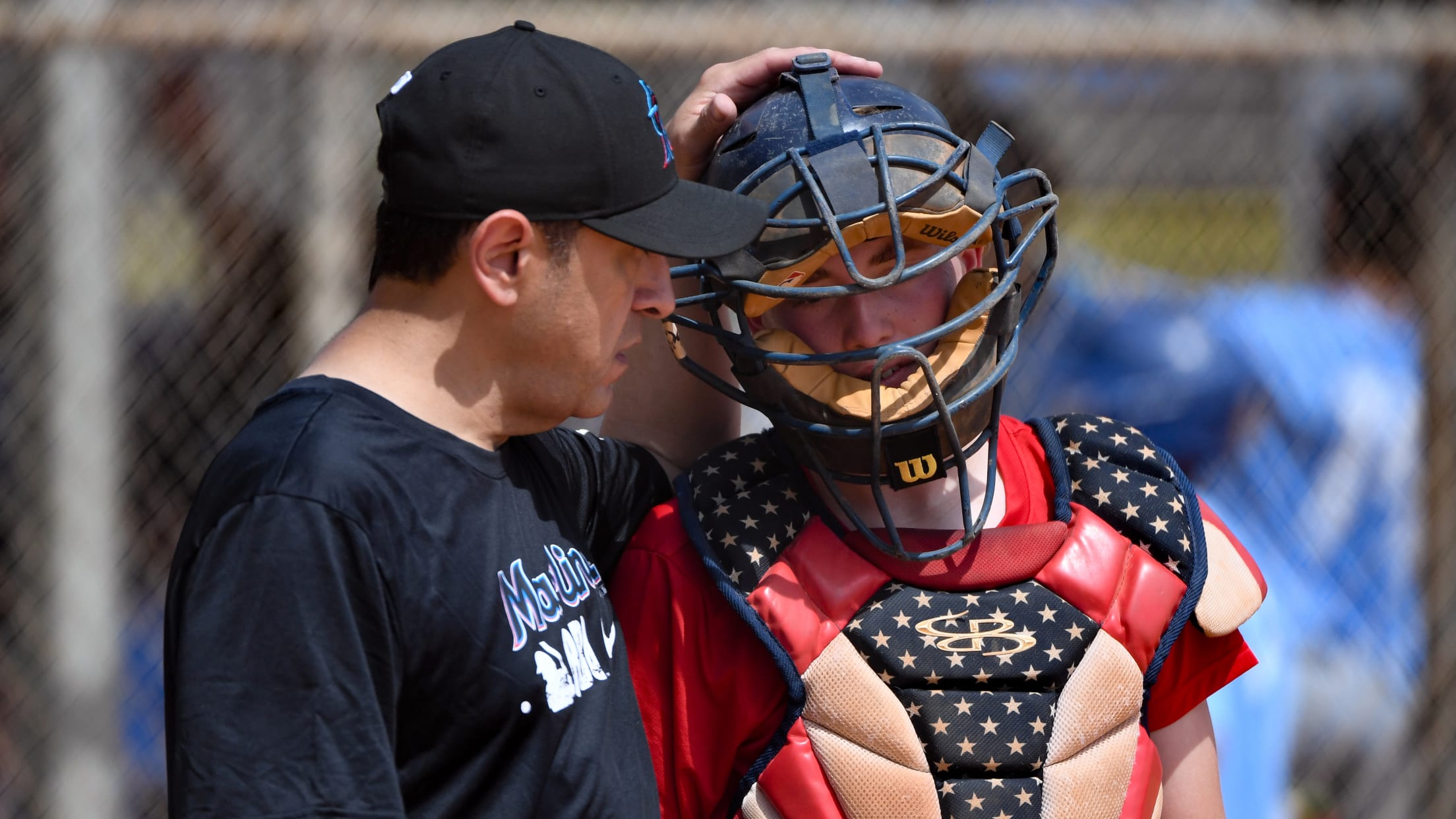A coach talks to his catcher.