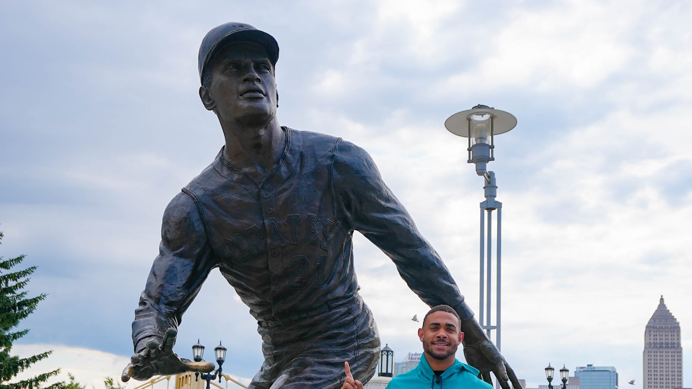 Julio Rodriguez takes a picture with the Roberto Clemente statue outside of PNC Park in Pittsburgh, Pa.