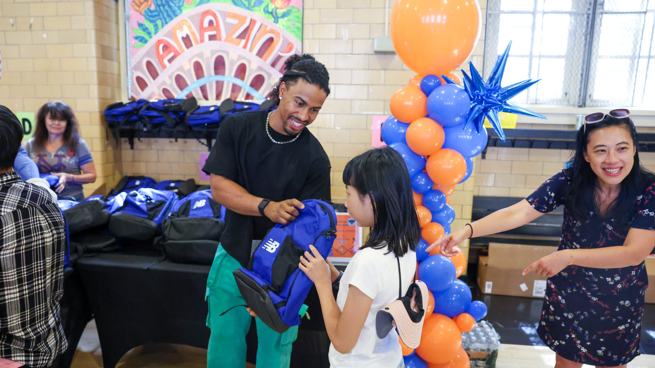 Francisco Lindor gifts a student a New Balance backpack.